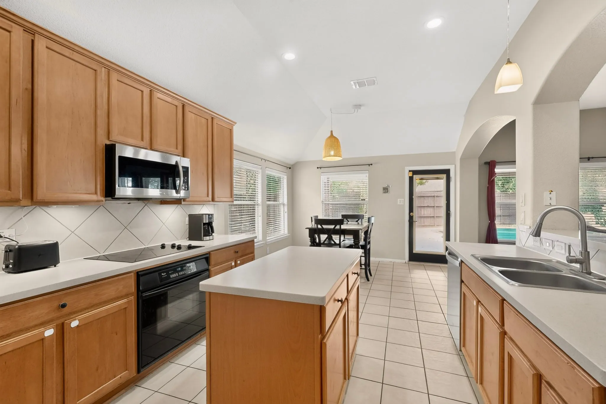 Kitchen featuring wood cabinetry, white countertops, tile flooring, and stainless steel appliances
