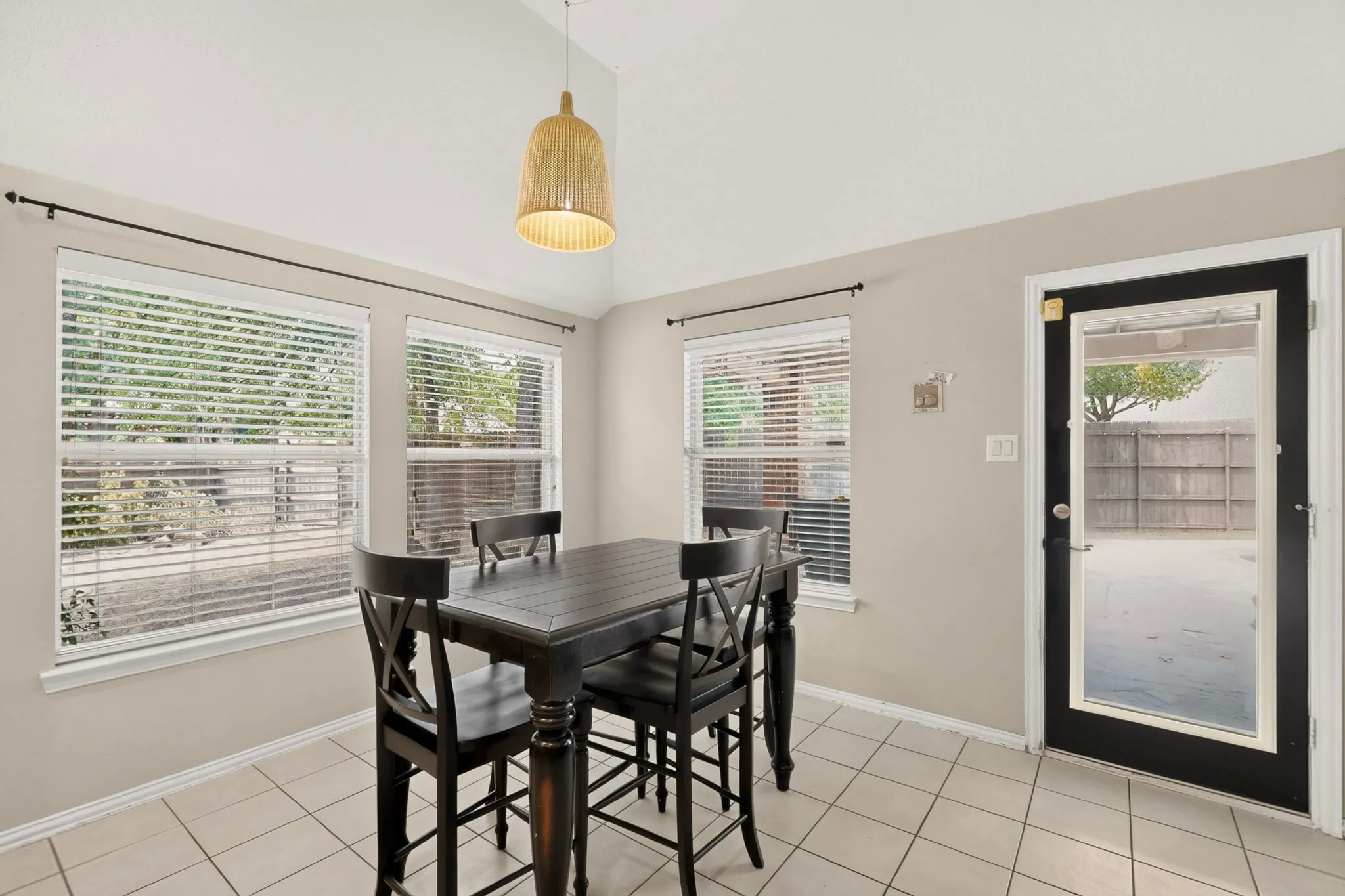 Vaulted ceiling, recessed lighting, multiple windows, ceramic tile flooring, and a full-light exterior door