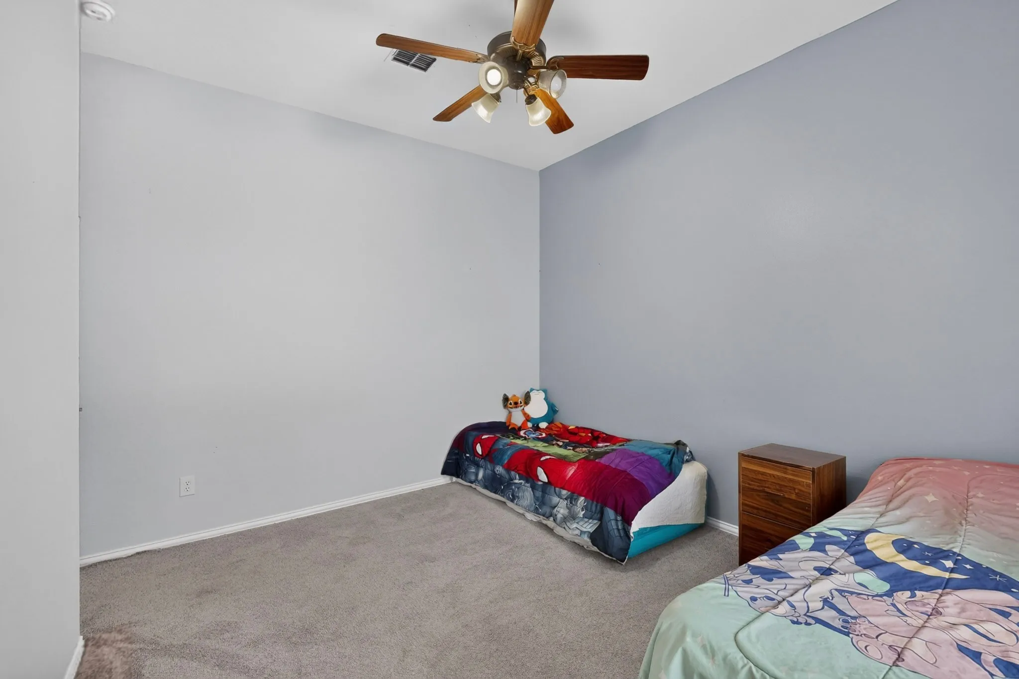 Plush carpeting, ceiling fan with integrated lighting, neutral wall palette