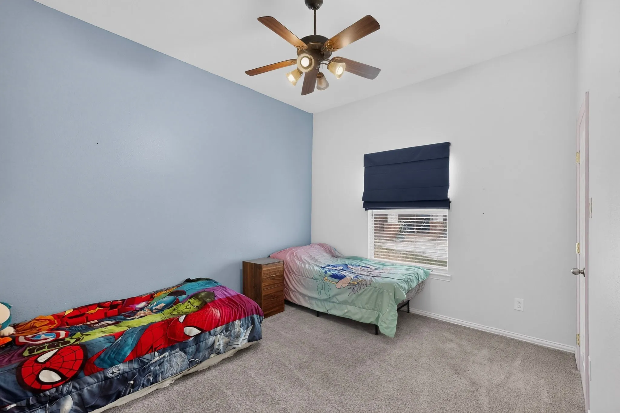 Neutral wall tones with an accent wall, carpeted flooring, and a ceiling fan with integrated lighting