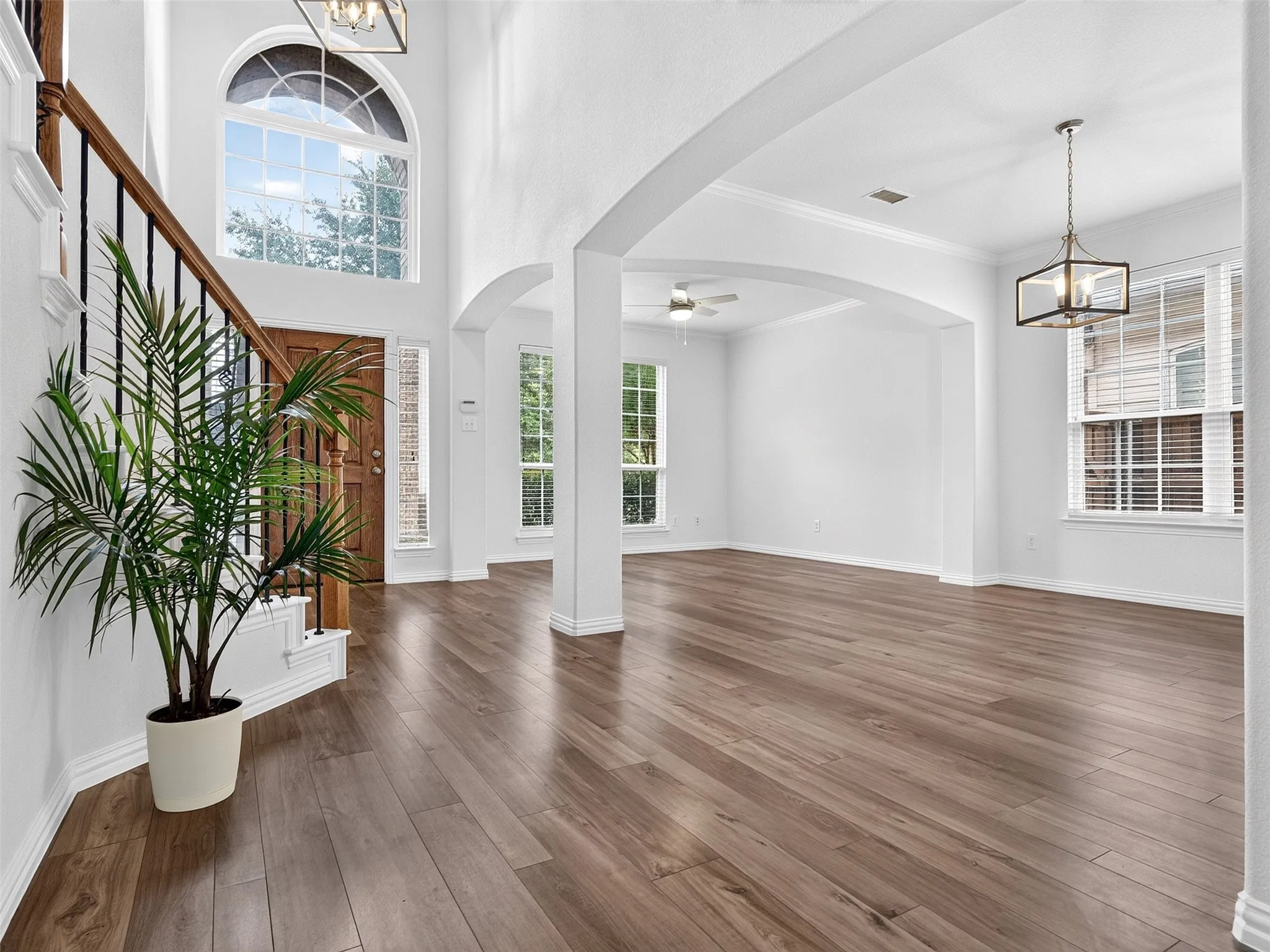 Two-story entryway with arched window and a wood-finish front door