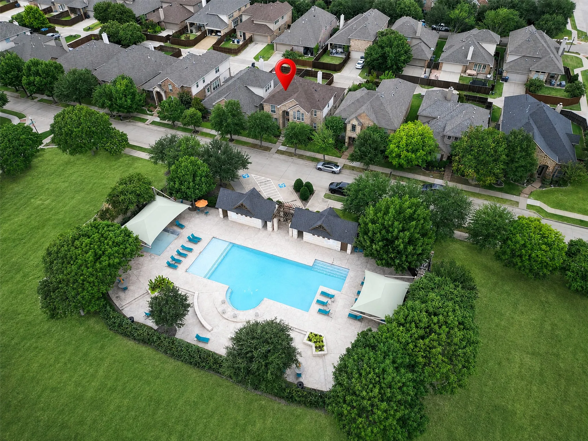 Community swimming pool with surrounding lounge chairs and shaded areas