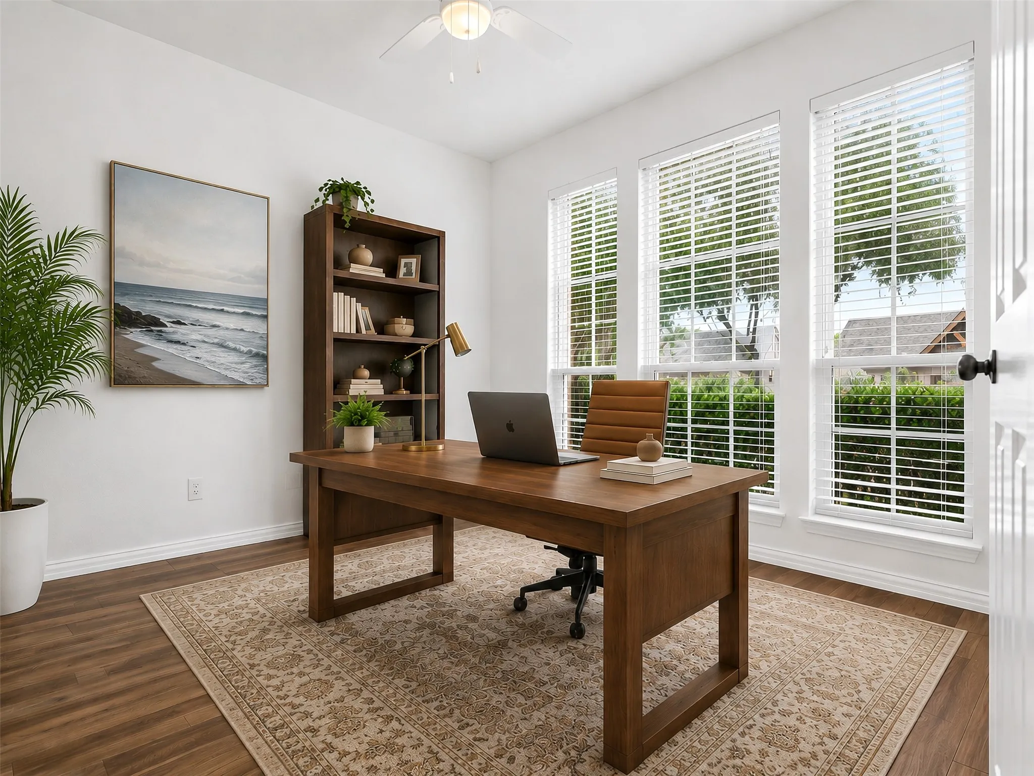 Wood-finish flooring with white baseboards, a wood-finish desk, and a wood-finish bookshelf