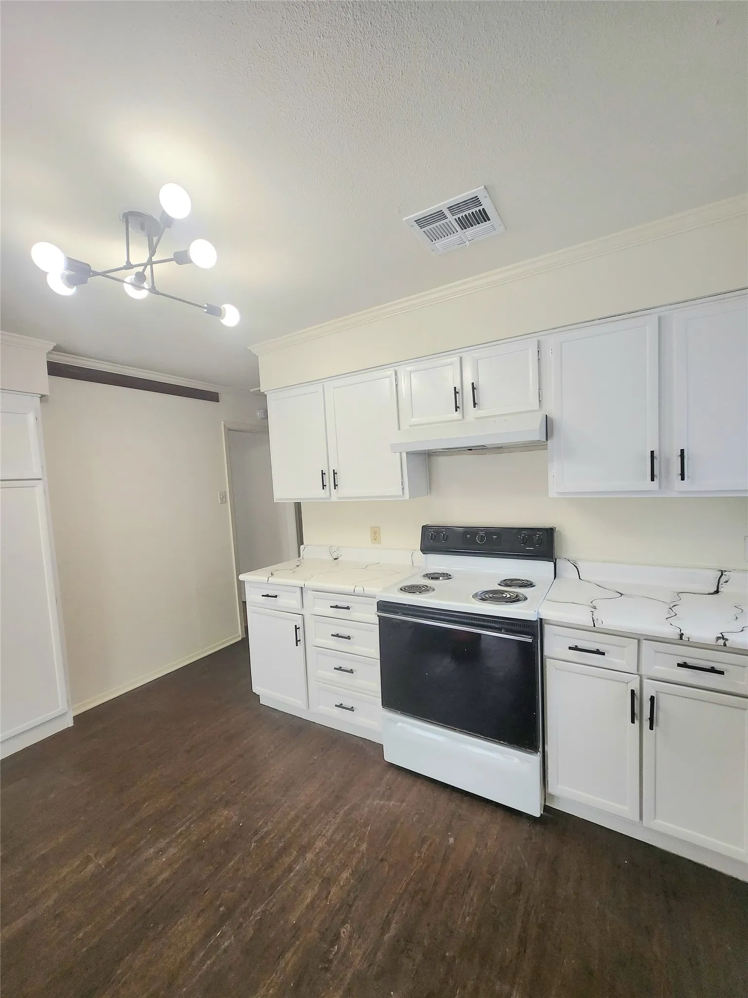 Kitchen featuring white cabinetry with dark hardware, a white range, light-toned countertops, and wood-finish flooring