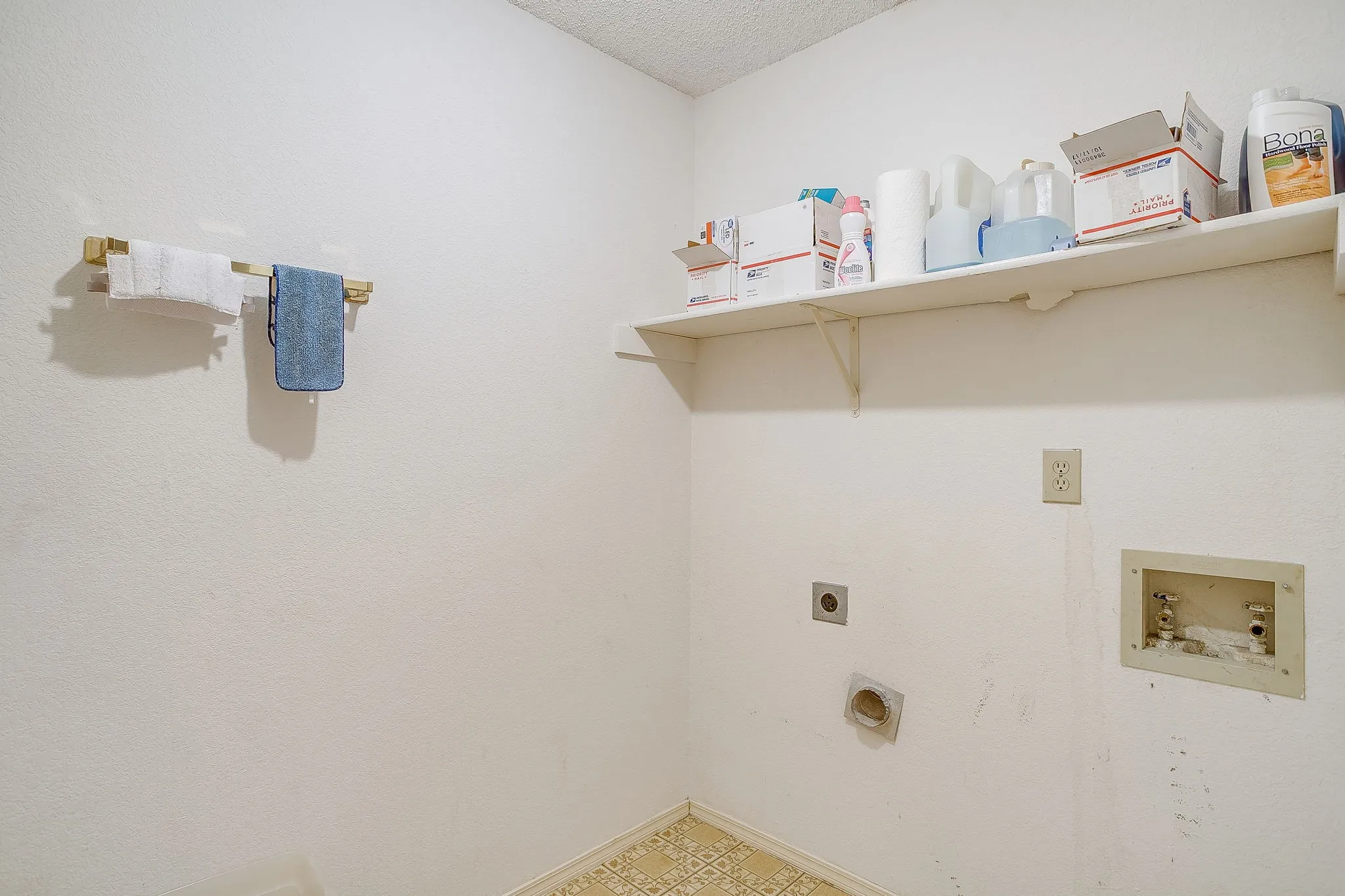 Separate utility room with washer and dryer hook ups along with a storage shelf.