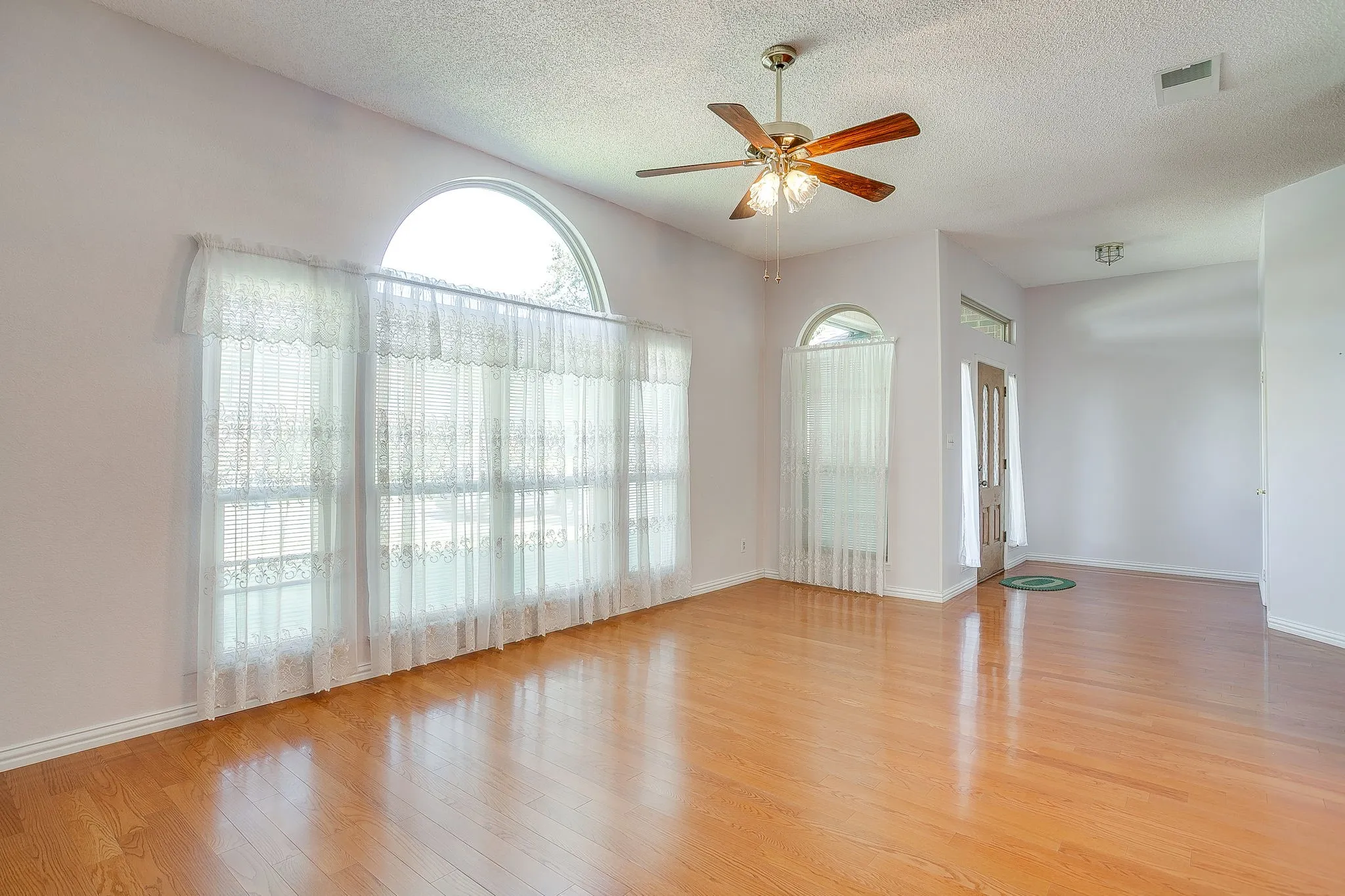 Large arched front window in your home floods the front living space with gorgeous natural light.