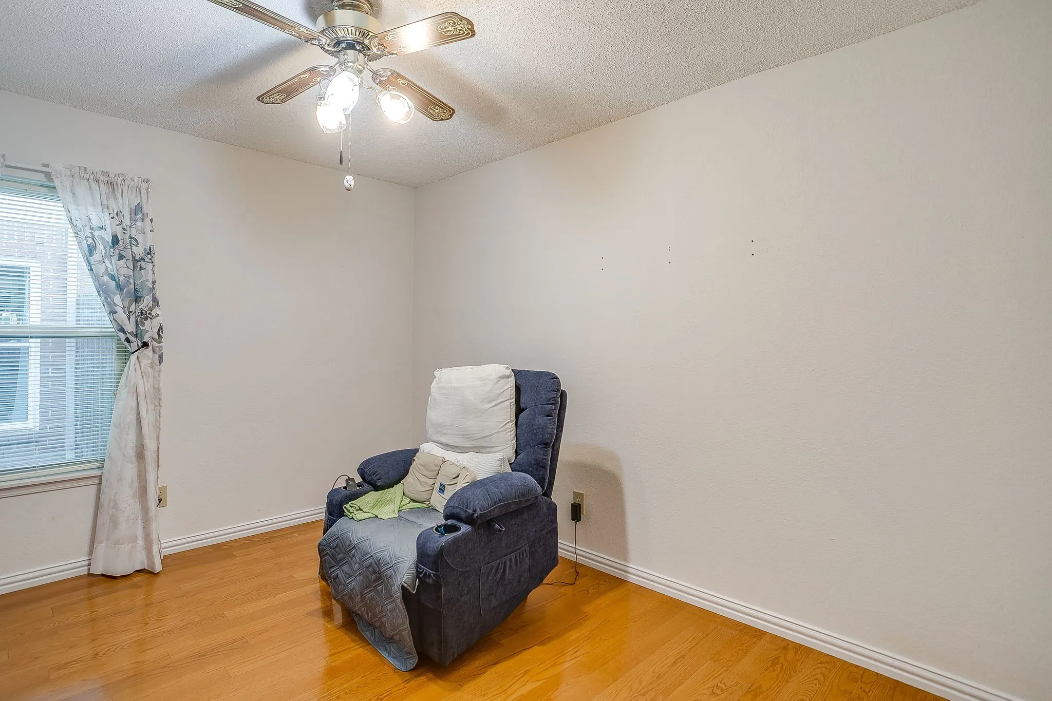 Secondary bedroom with wood flooring.