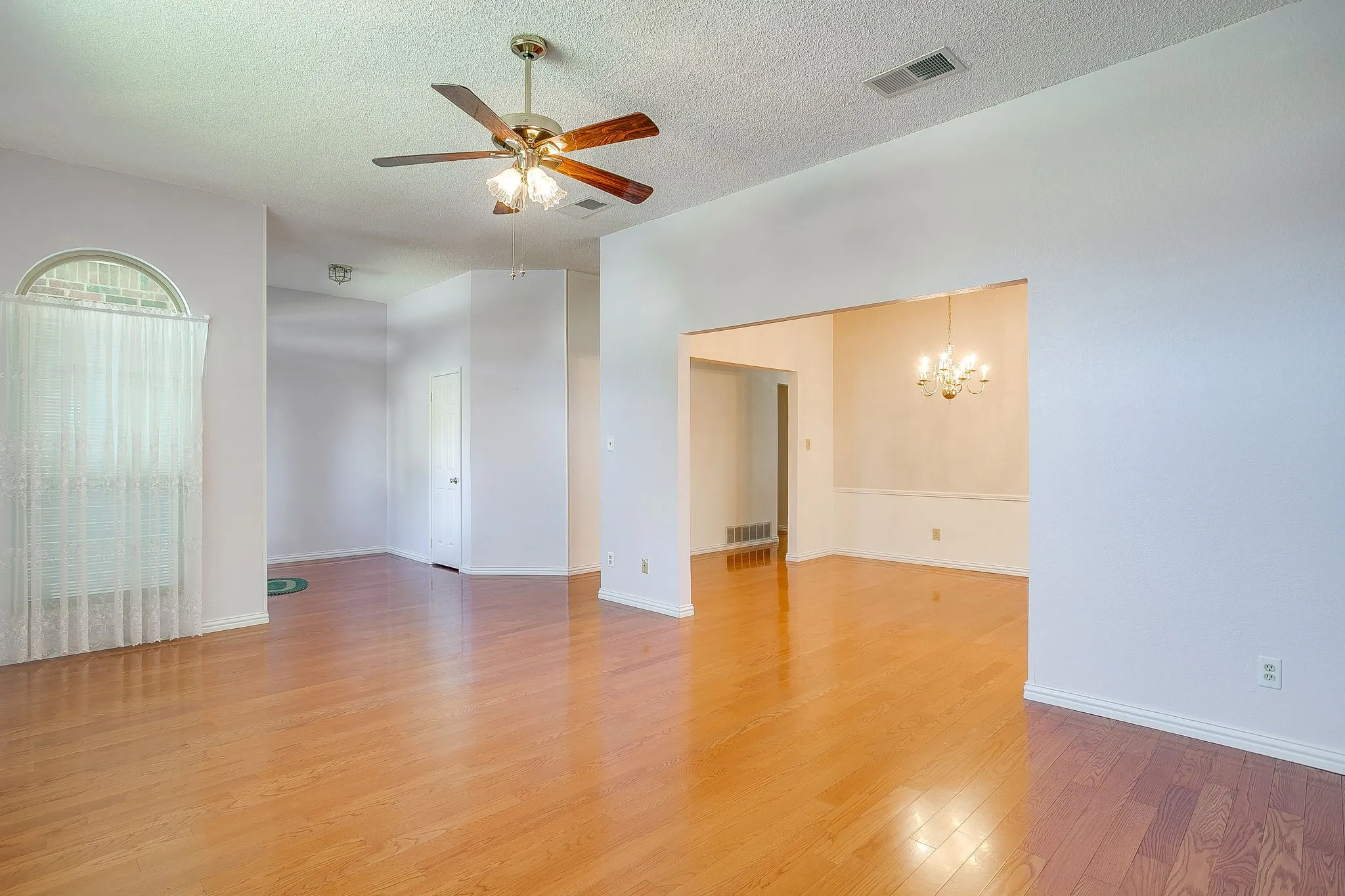 Gorgeous, warm wood flooring flows seamlessly throughout the primary living, dining, and entry areas.