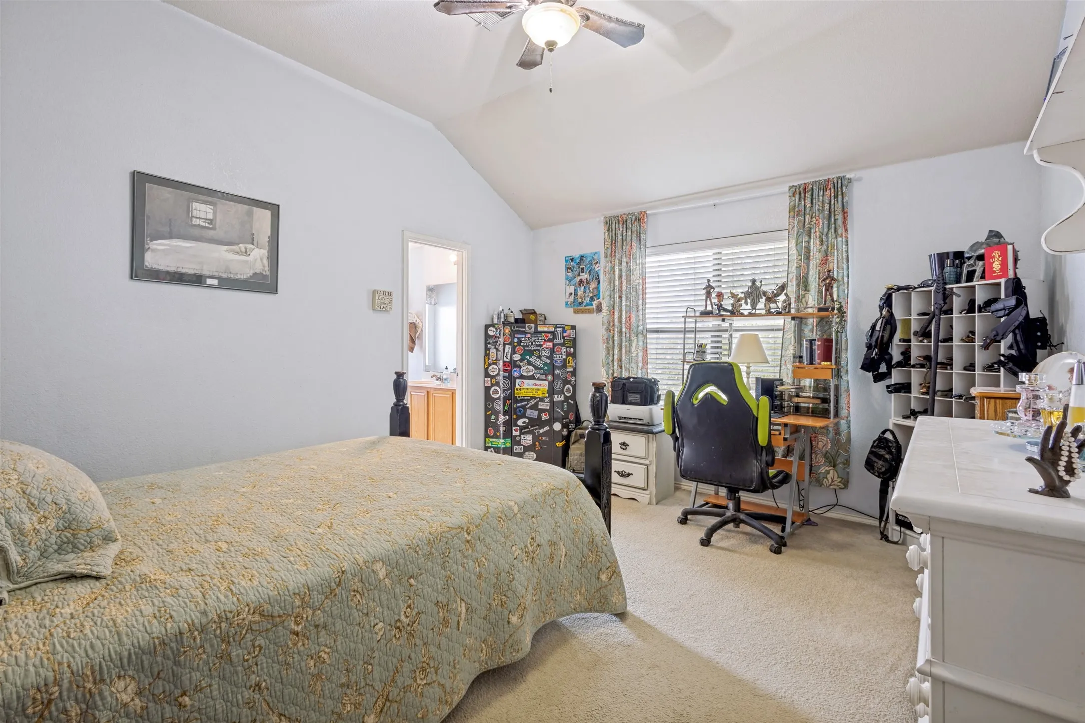 Vaulted ceiling featuring a ceiling fan with integrated lighting, carpet flooring, and a window with blinds