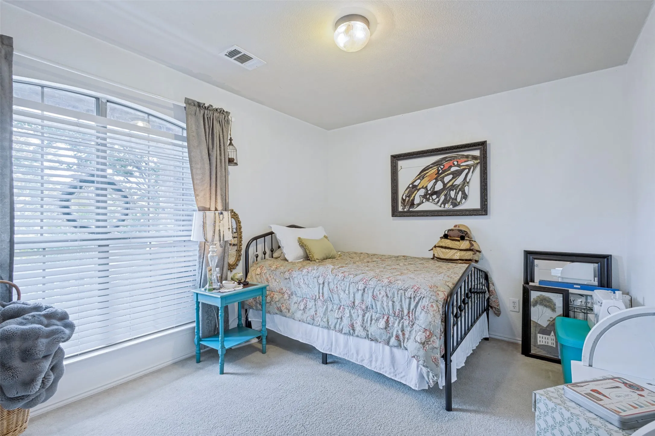 Carpeted flooring, arched window, and ceiling-mounted light fixture