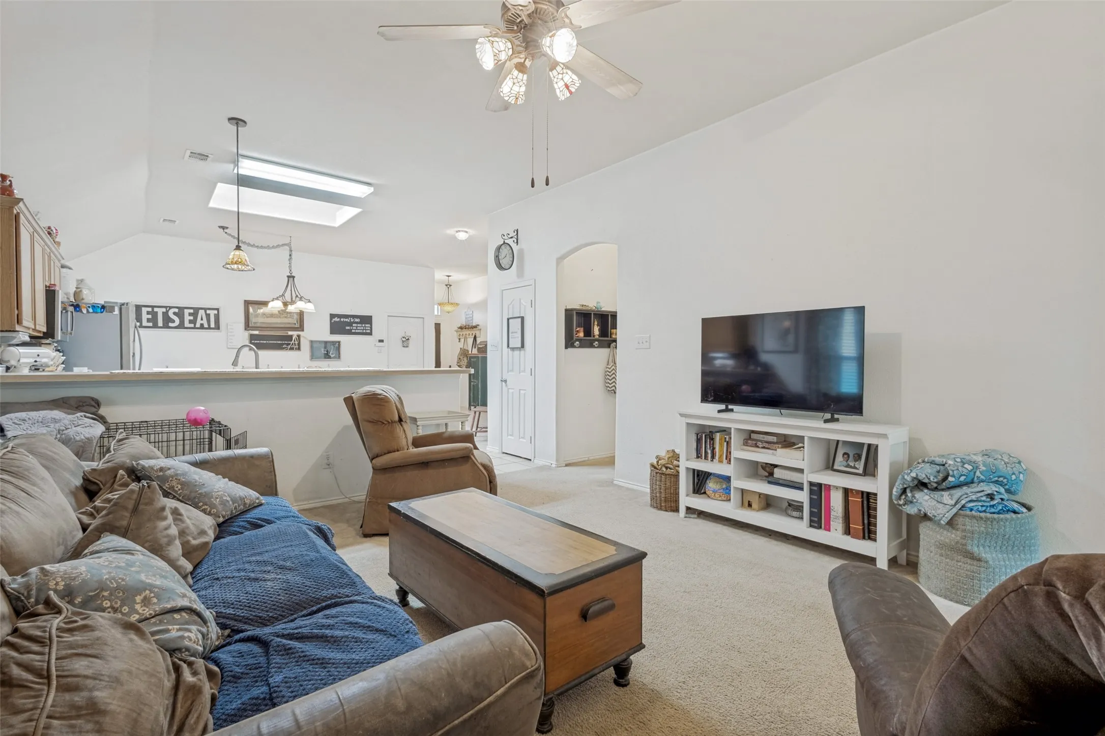 Vaulted ceilings enhance the living space, featuring a ceiling fan.