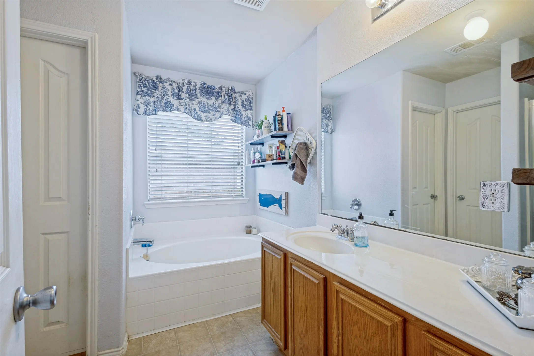 Full-width vanity, separate garden tub with plenty of space for two in the closet.
