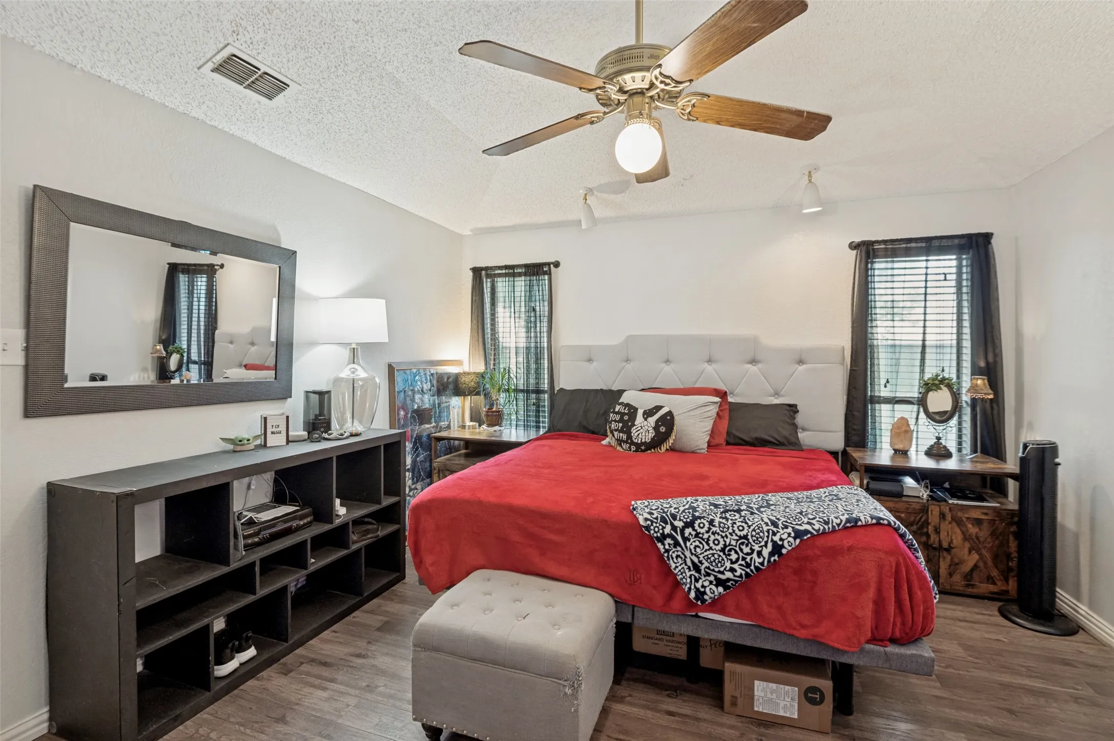 Vaulted ceiling with a ceiling fan, wood-finish flooring