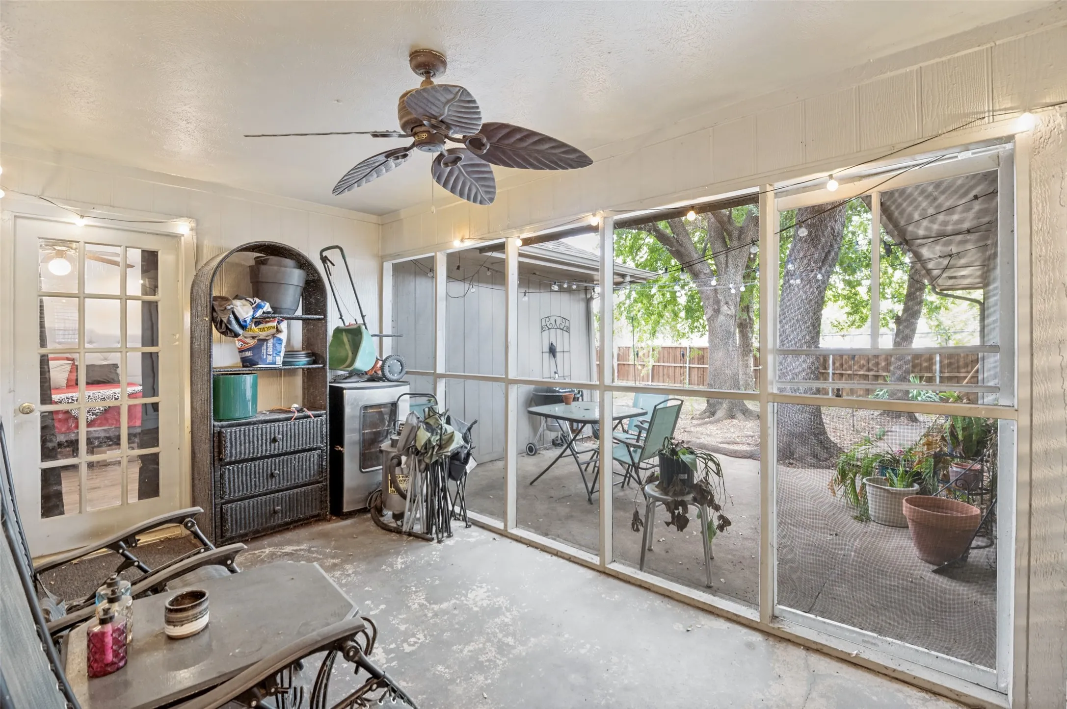 Screened-in porch with ceiling fan and concrete flooring