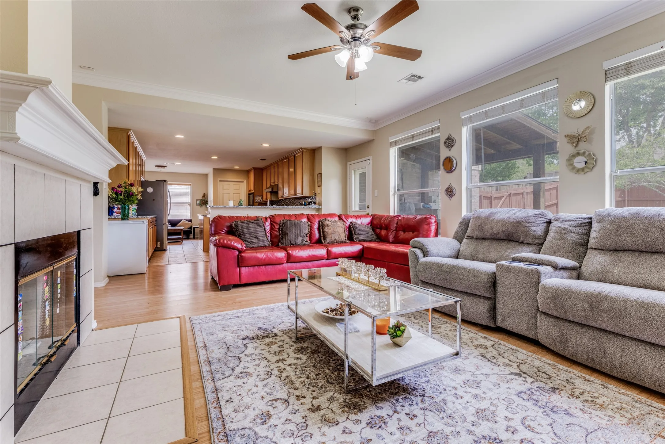 Living area featuring a fireplace with a white mantel, light wood-finish flooring, and multiple windows