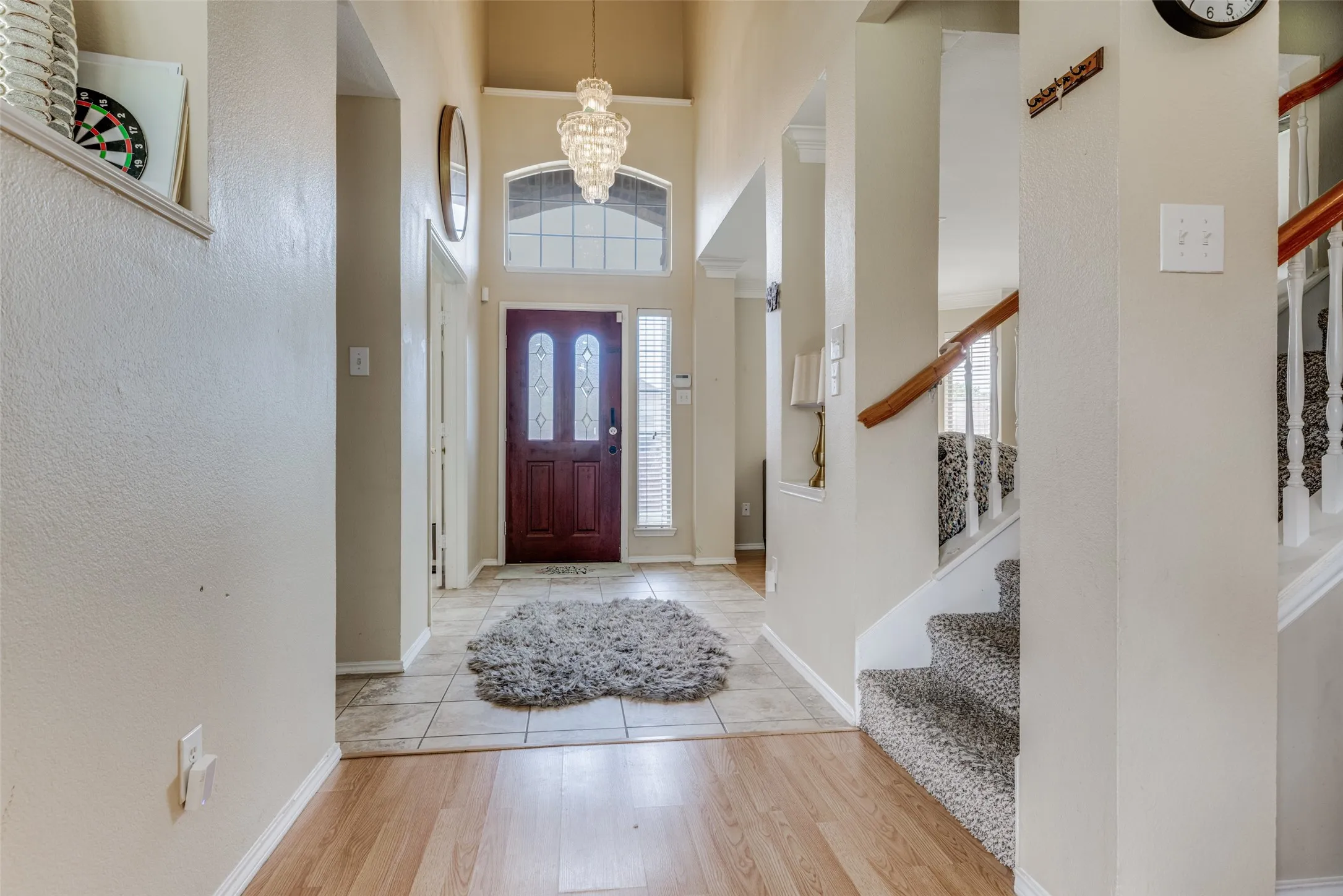 Entryway featuring a decorative chandelier, tall ceilings, a wood-panel front door with glass inserts, and a tiled floor