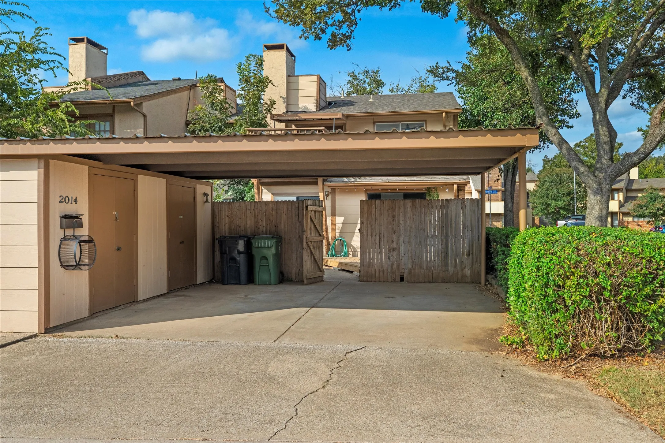 Covered carport with concrete driveway and attached garage featuring great storage