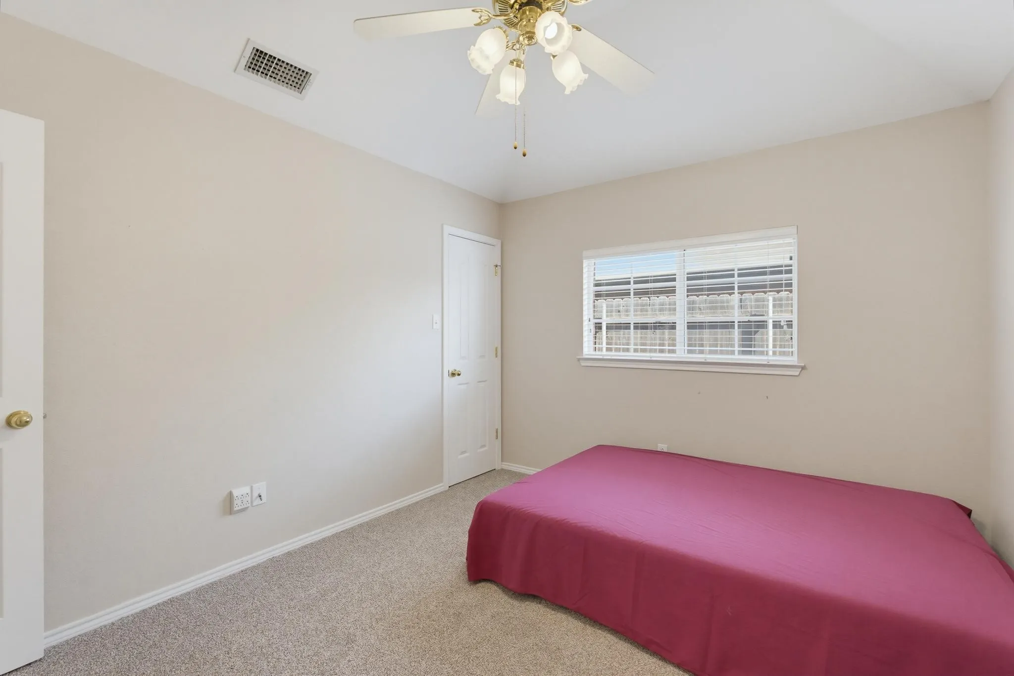 Neutral wall paint, carpet flooring, a ceiling fan with integrated lighting, and a window with blinds