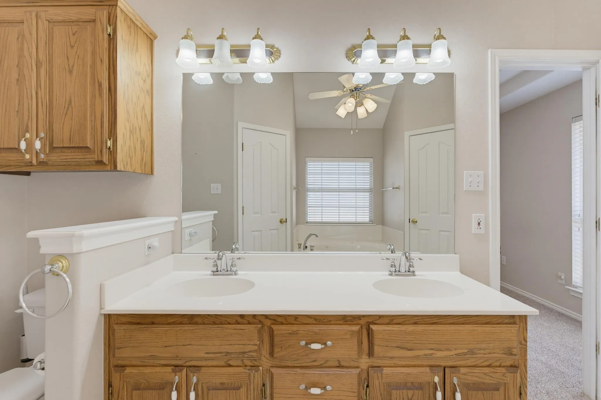 Dual vanity with a white countertop and wood-finish cabinetry