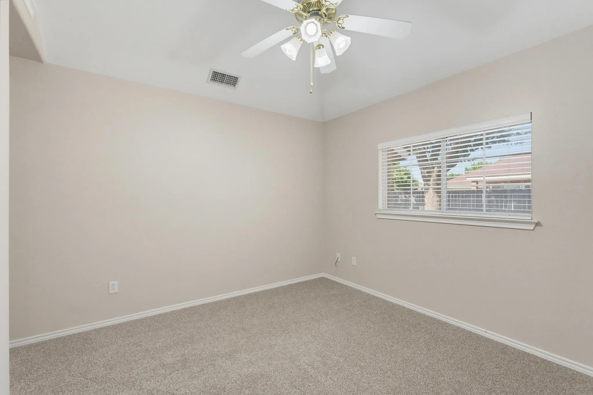 Vaulted ceiling with a ceiling fan, neutral carpeting, and a window with blinds