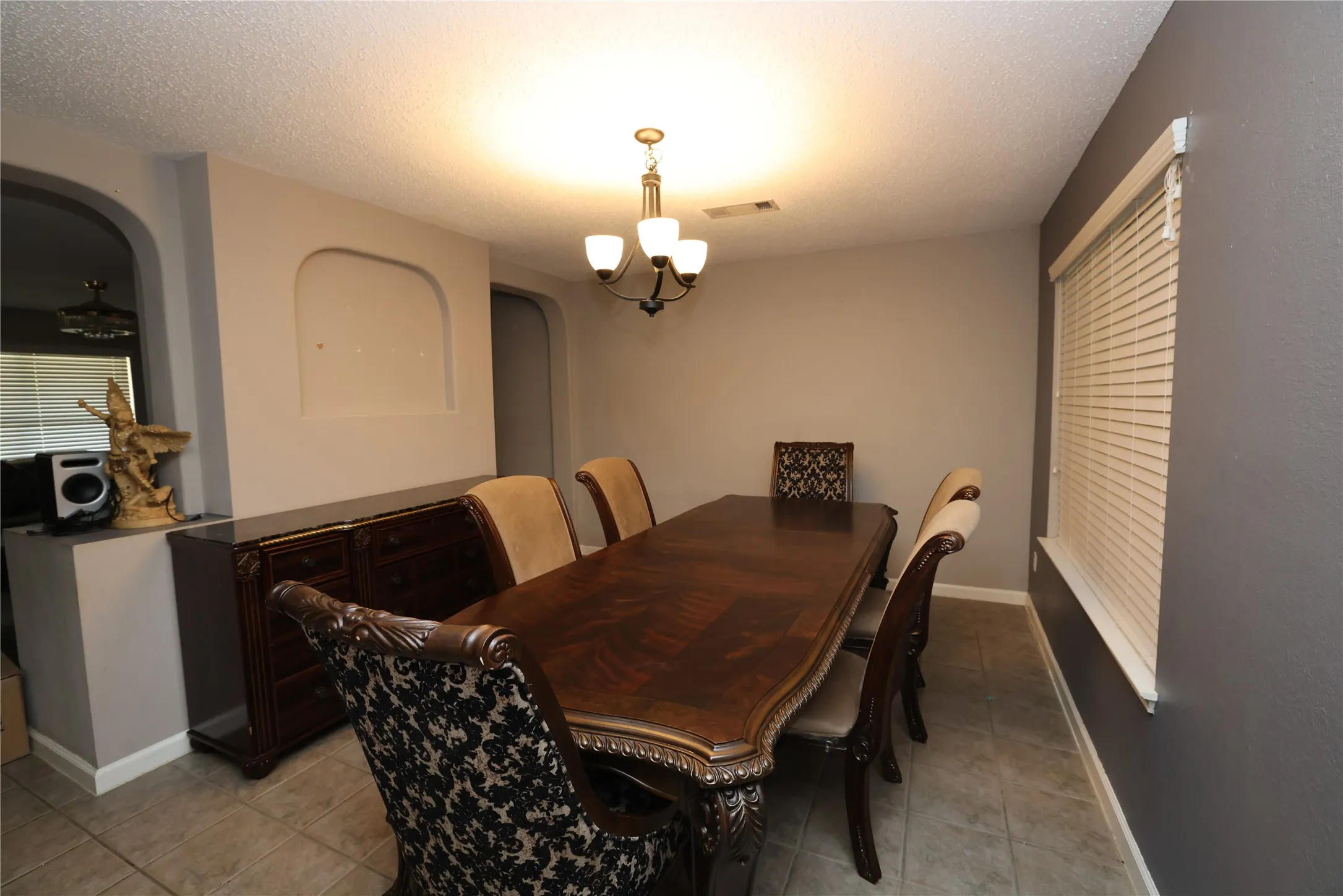Recessed wall niche, arched doorway, and tiled flooring