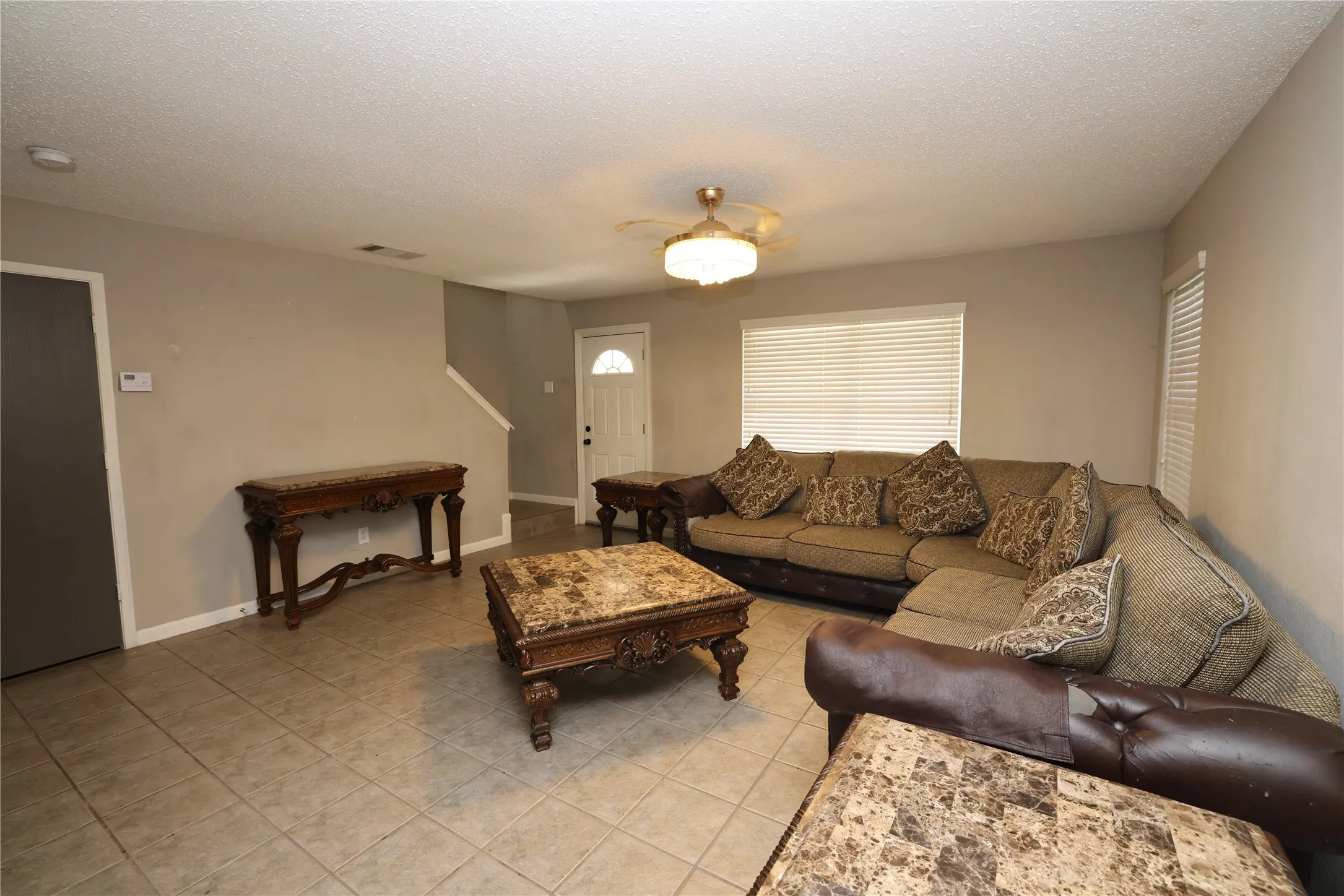 Tile flooring, neutral wall paint, white interior doors, and a ceiling fan with integrated lighting