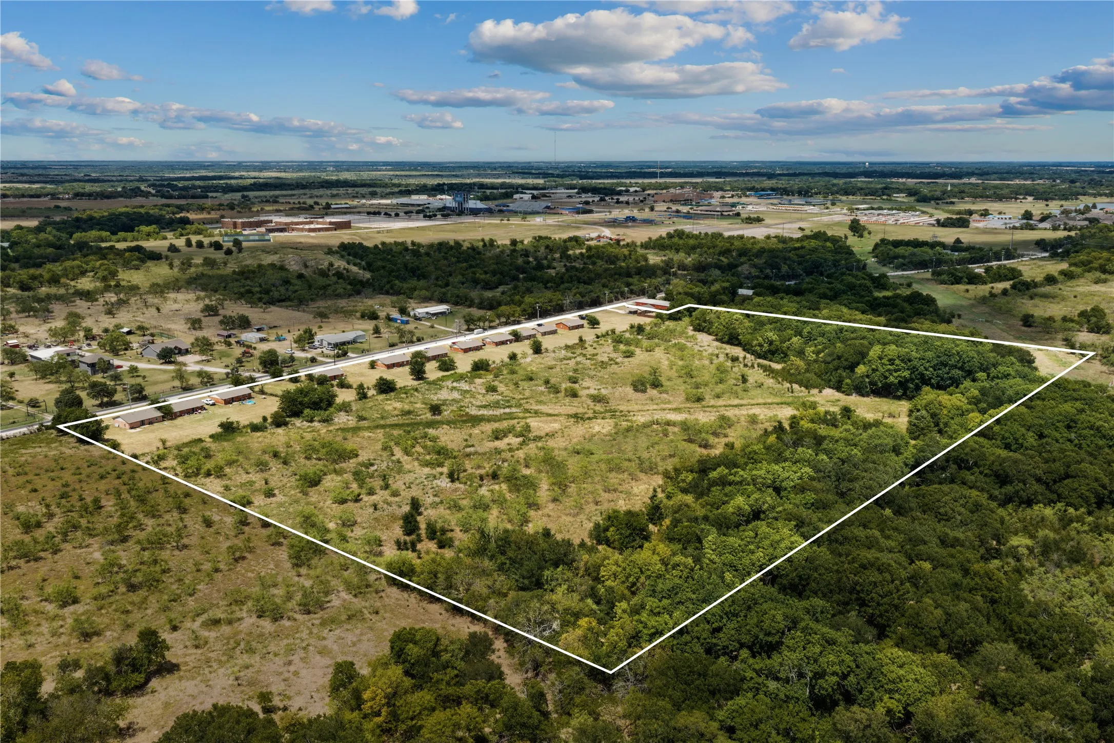 Expansive land parcel featuring a mix of open areas and mature tree coverage