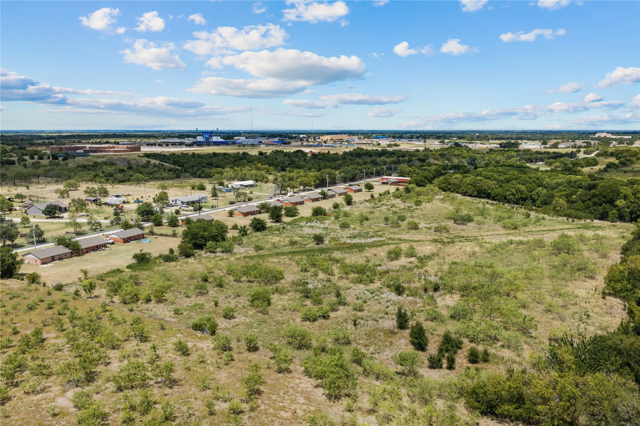 Expansive undeveloped land featuring natural vegetation and scattered trees