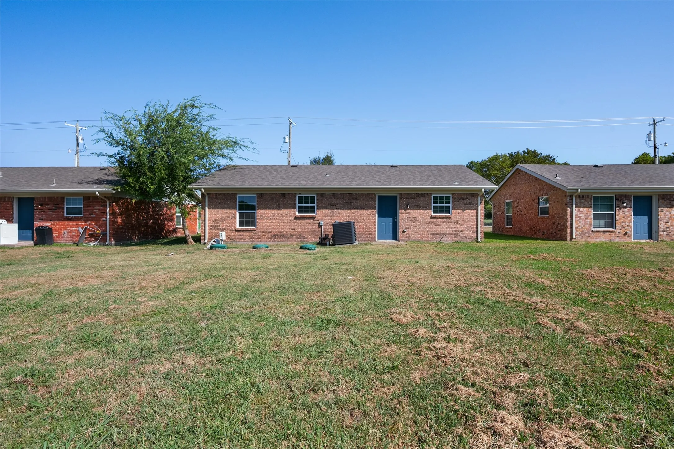 Brick exteriors with blue entry doors and white-framed windows