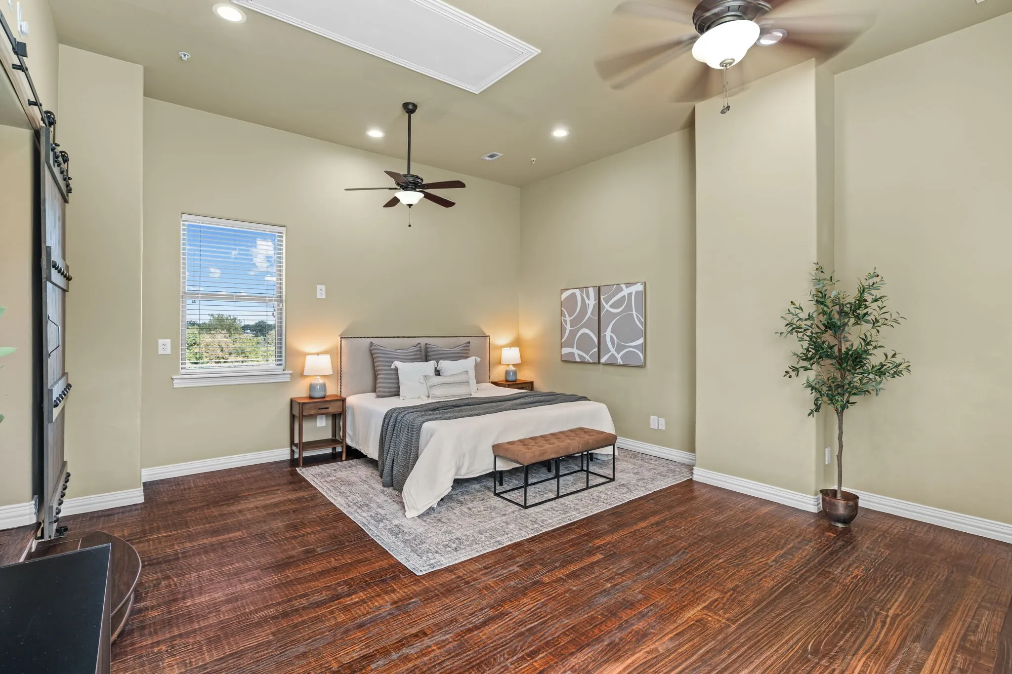 Secondary living space 5th bedroom (no closet) is plumbed for a full en-suite bathroom Wood-finish flooring with recessed lighting, a ceiling fan, and a single window with blinds