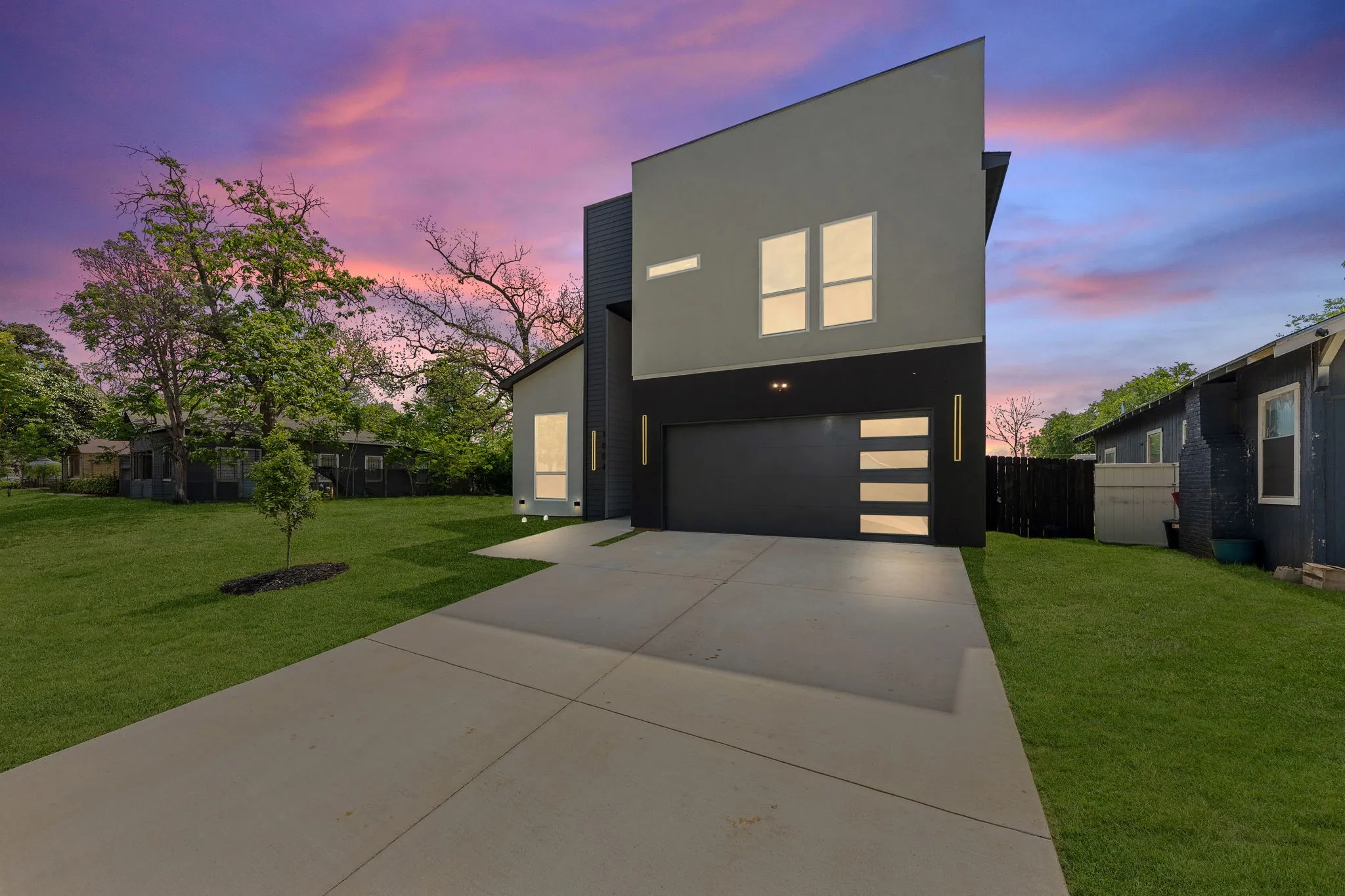 Modern exterior with a distinctive sloped roofline, attached two-car garage, and a concrete driveway