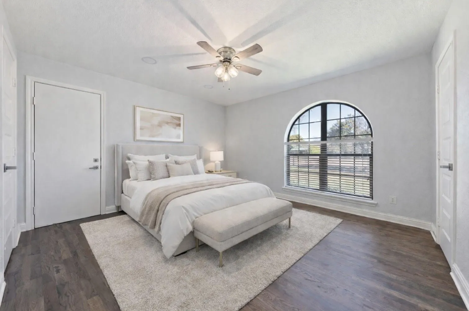 Arched window with black mullions, wood-finish flooring, ceiling fan with integrated lighting, and recessed ceiling lights