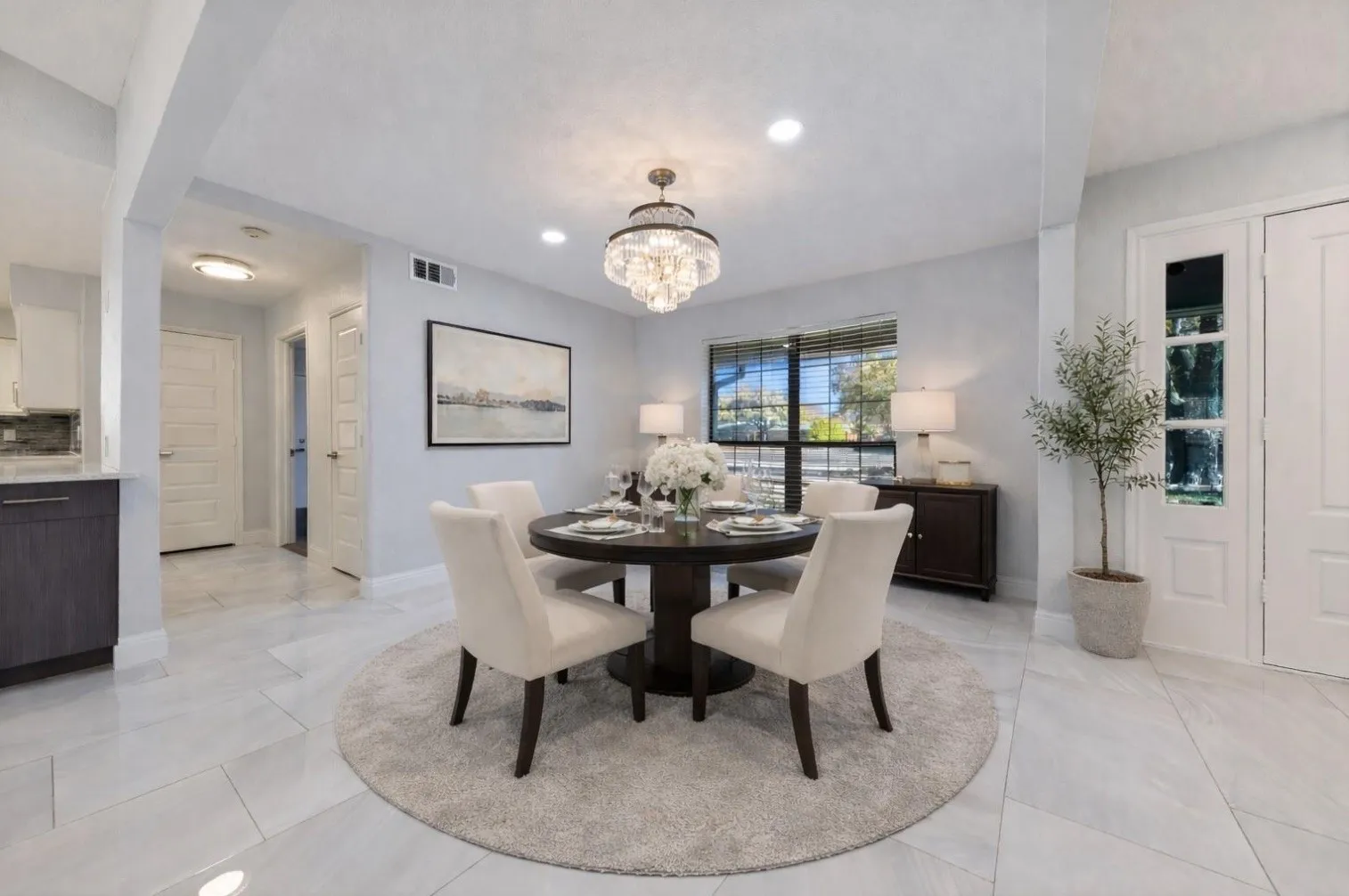 Dining area featuring an ornate chandelier, recessed lighting, and a large window with blinds