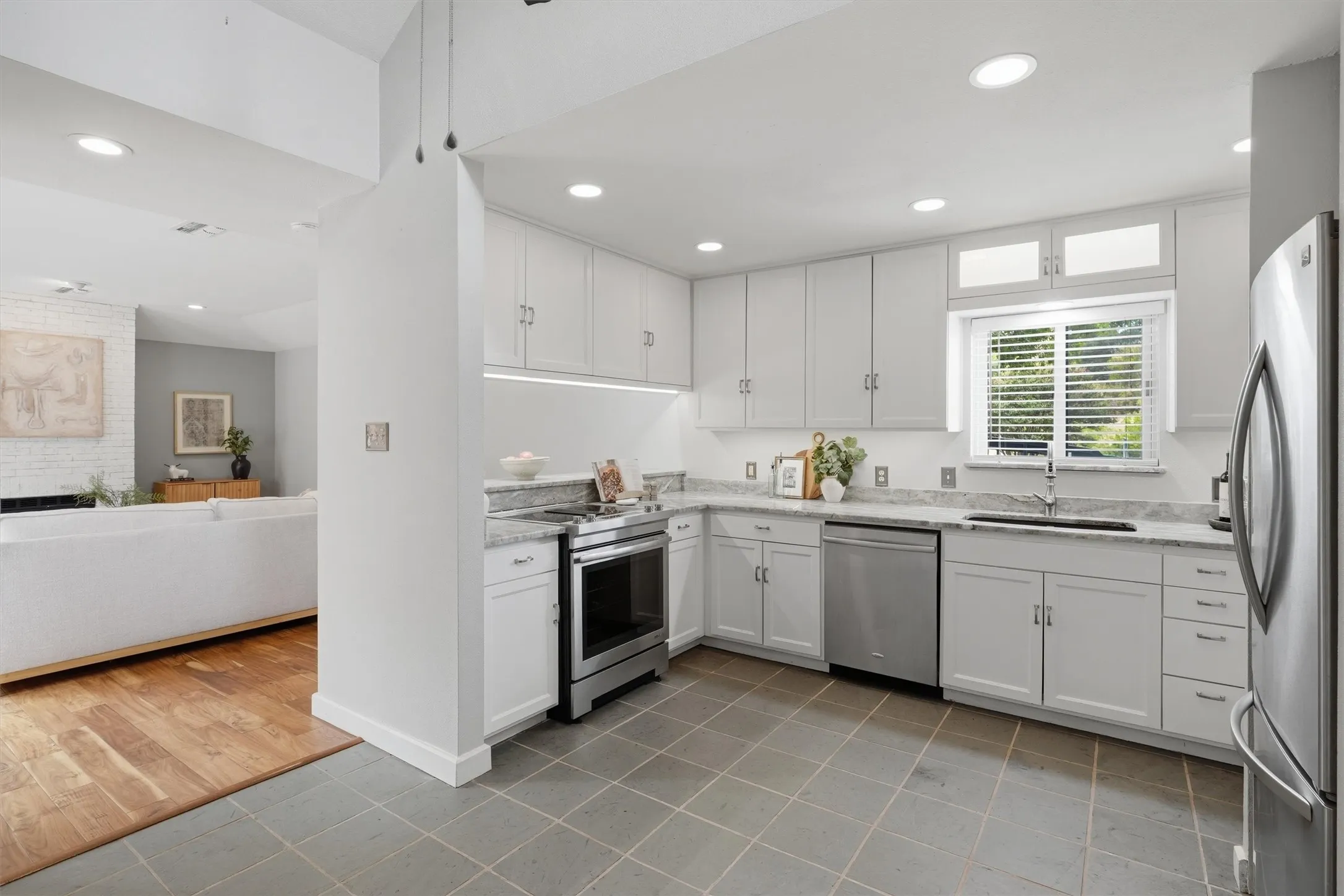 Kitchen that combines functional prep space and sleek stone countertops, breakfast bar, and clear view to main living area.