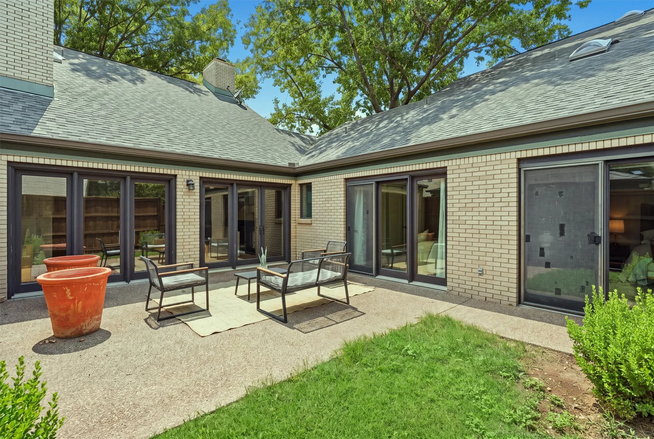 Showcasing exceptional indoor-outdoor design, this private L-shaped courtyard features multiple sets of glass doors connecting both living spaces and bedrooms directly to the spacious patio.