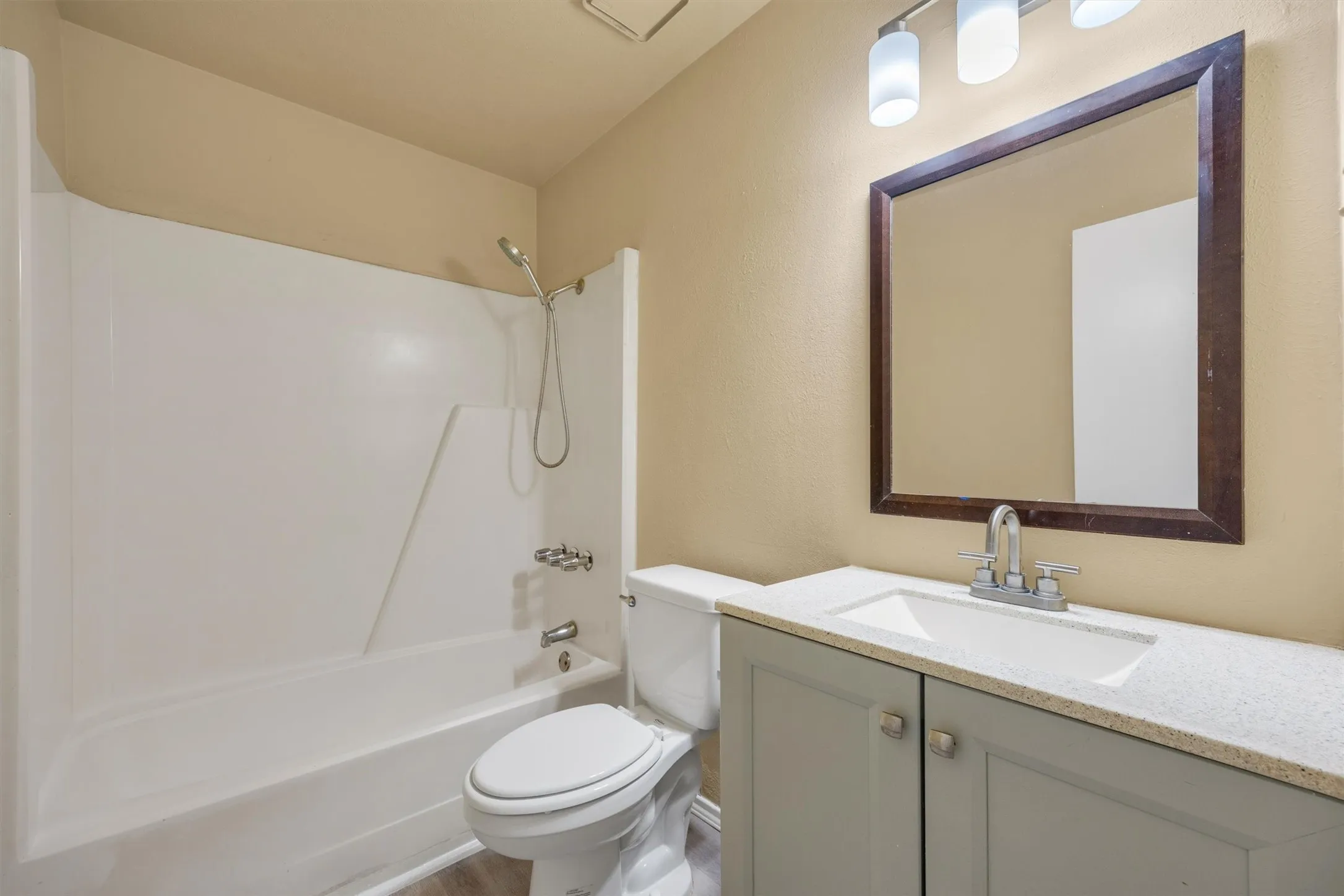 Spa-inspired bathroom featuring a vanity with dual cabinet storage, white quartz countertop, and brushed nickel faucet