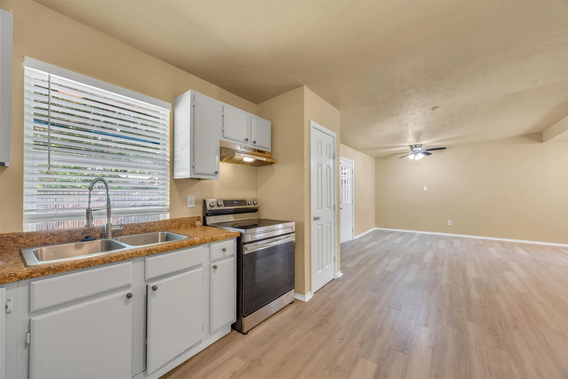 Kitchen featuring white cabinetry, a double basin stainless steel sink, and stainless steel appliances