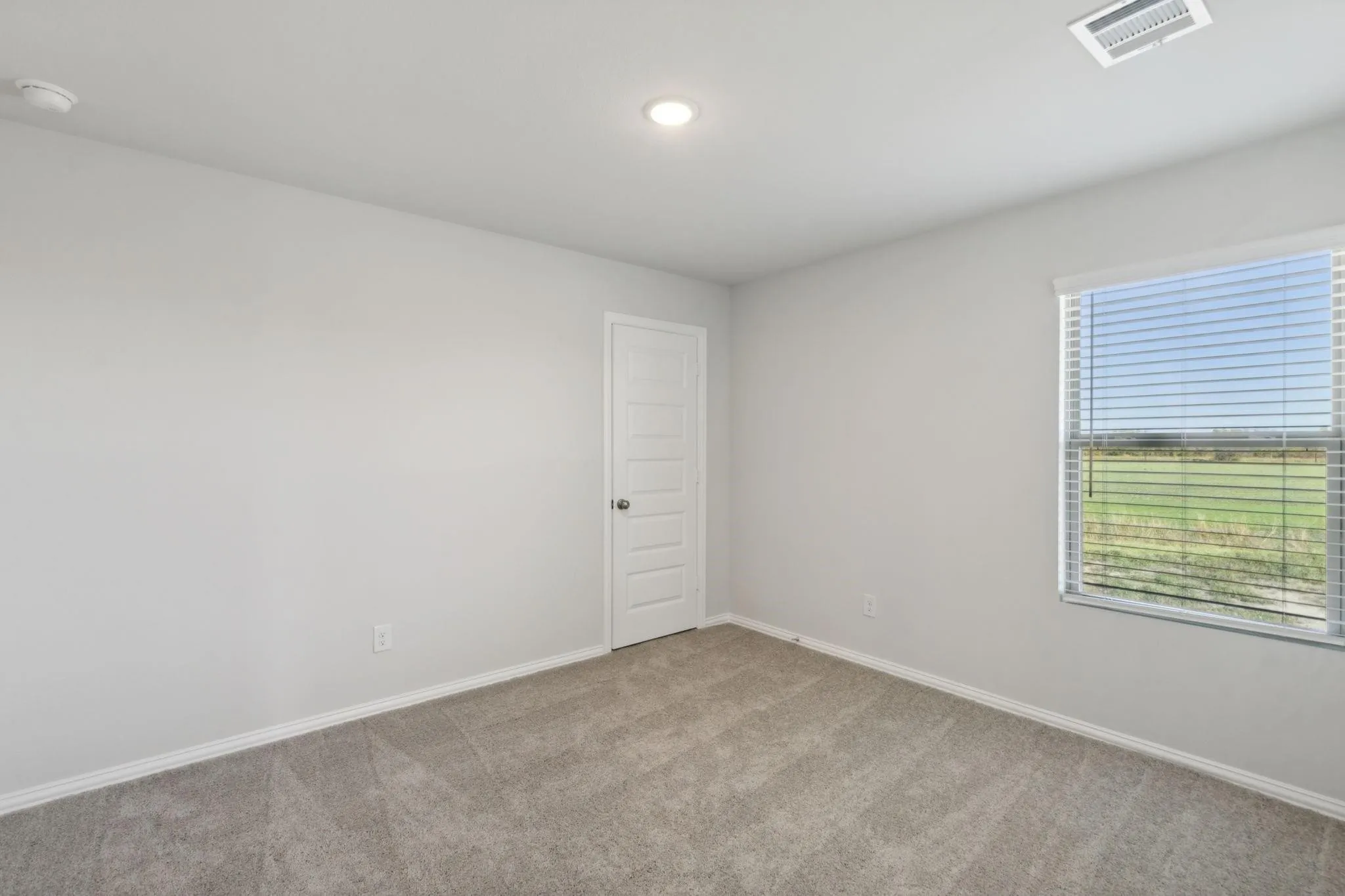 Spare room featuring light colored carpet, baseboards, a smoke detector, and recessed lighting