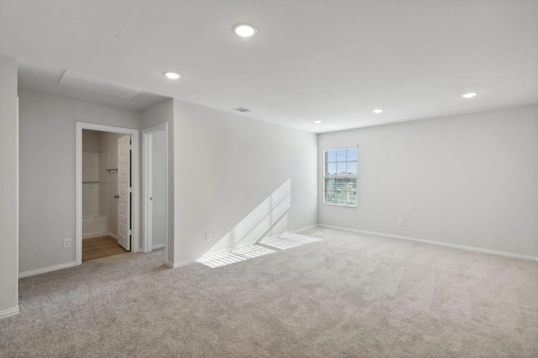 Spare room featuring light carpet, baseboards, and recessed lighting