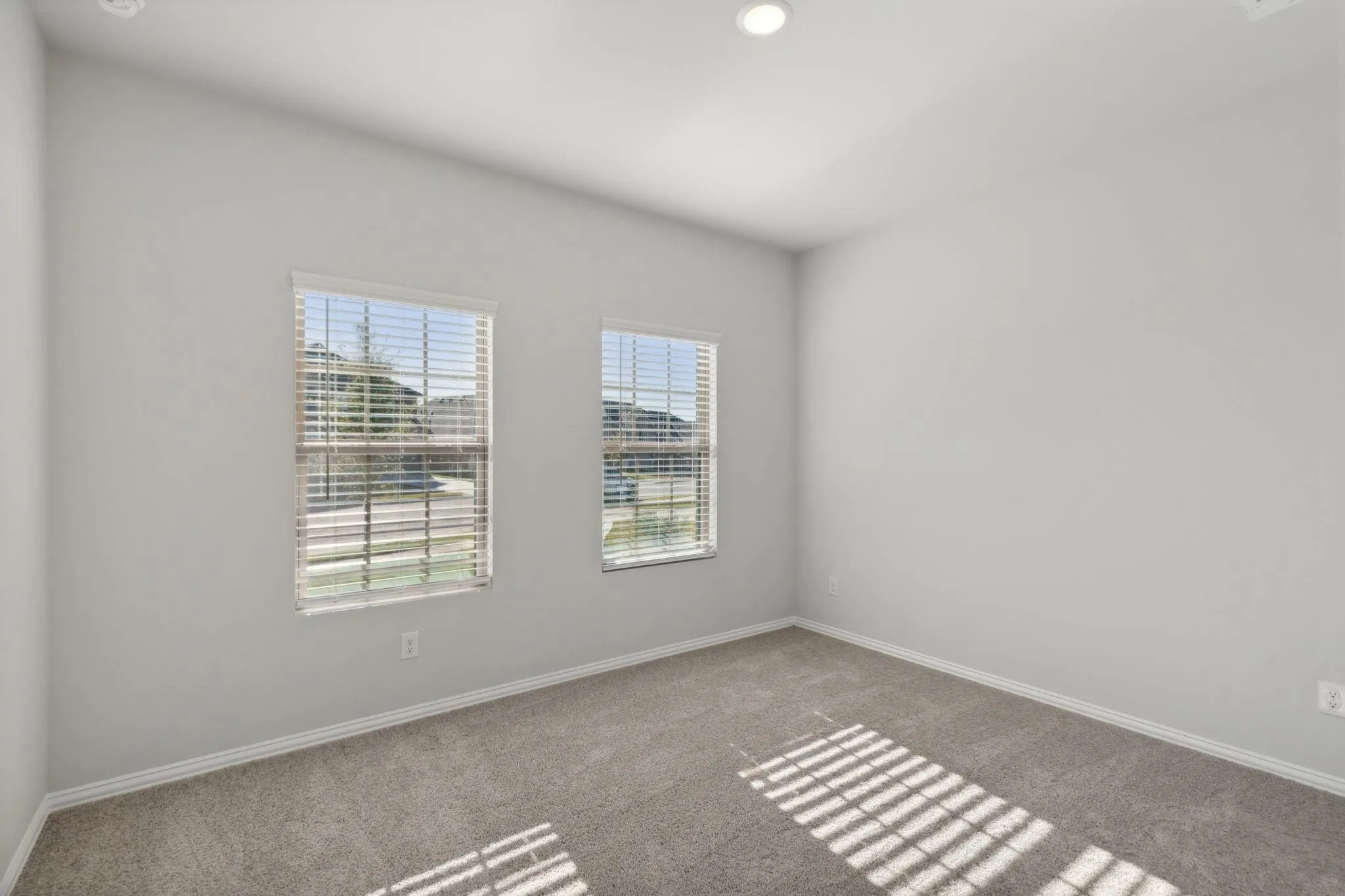 Spare room featuring carpet floors, plenty of natural light, baseboards, and recessed lighting