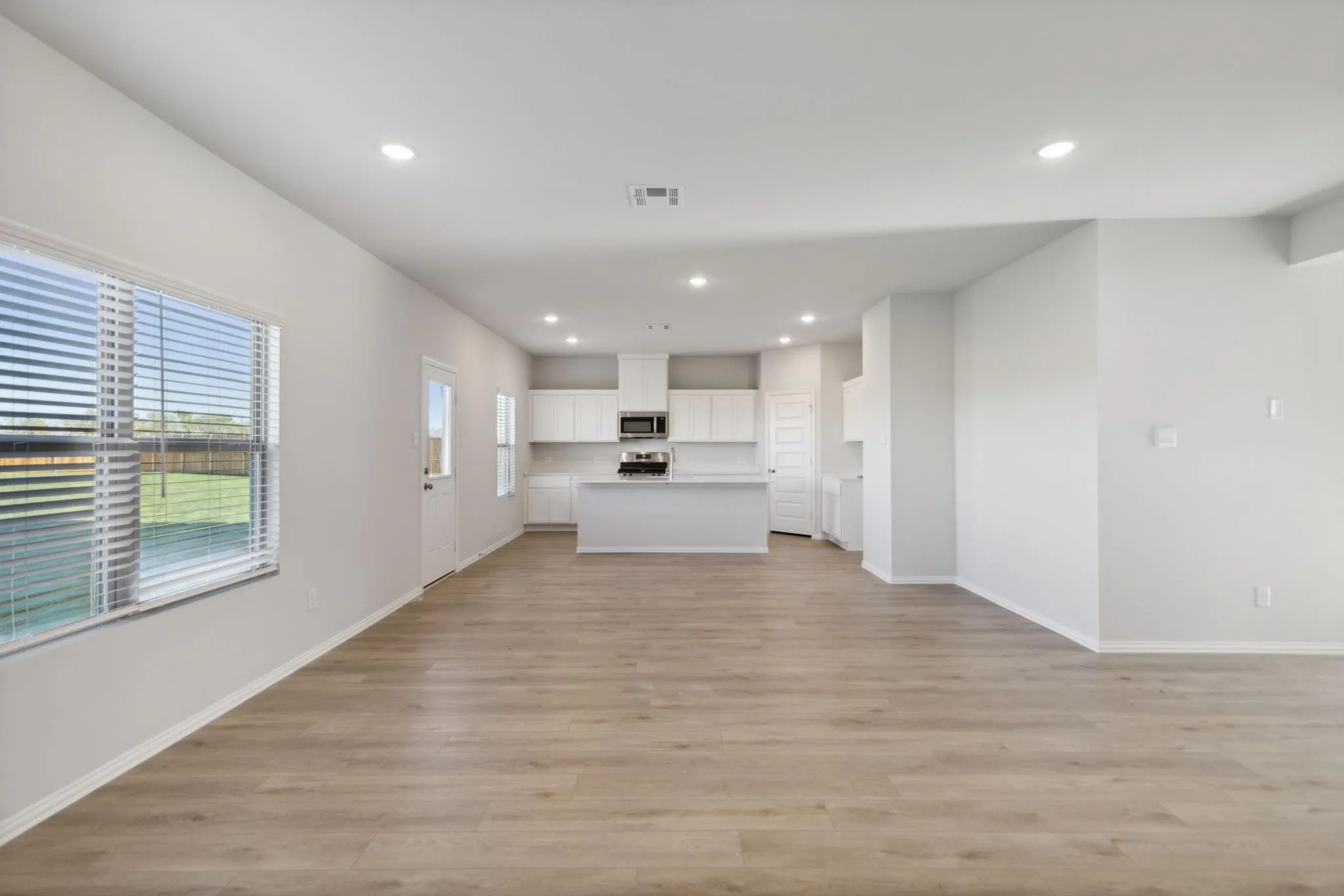 Unfurnished living room featuring light wood-style floors, recessed lighting, and baseboards