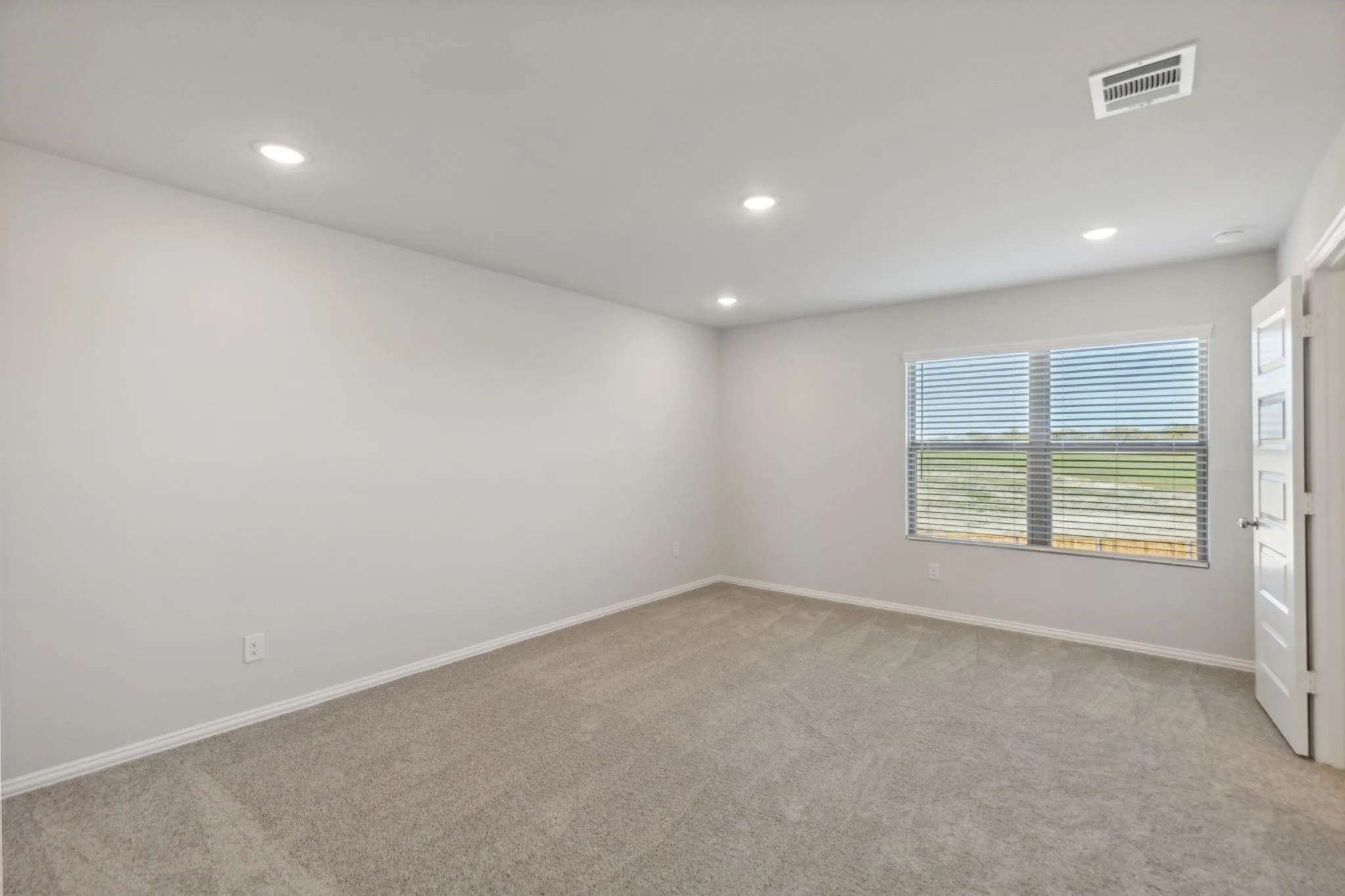 Unfurnished room with light colored carpet, recessed lighting, healthy amount of natural light, and baseboards