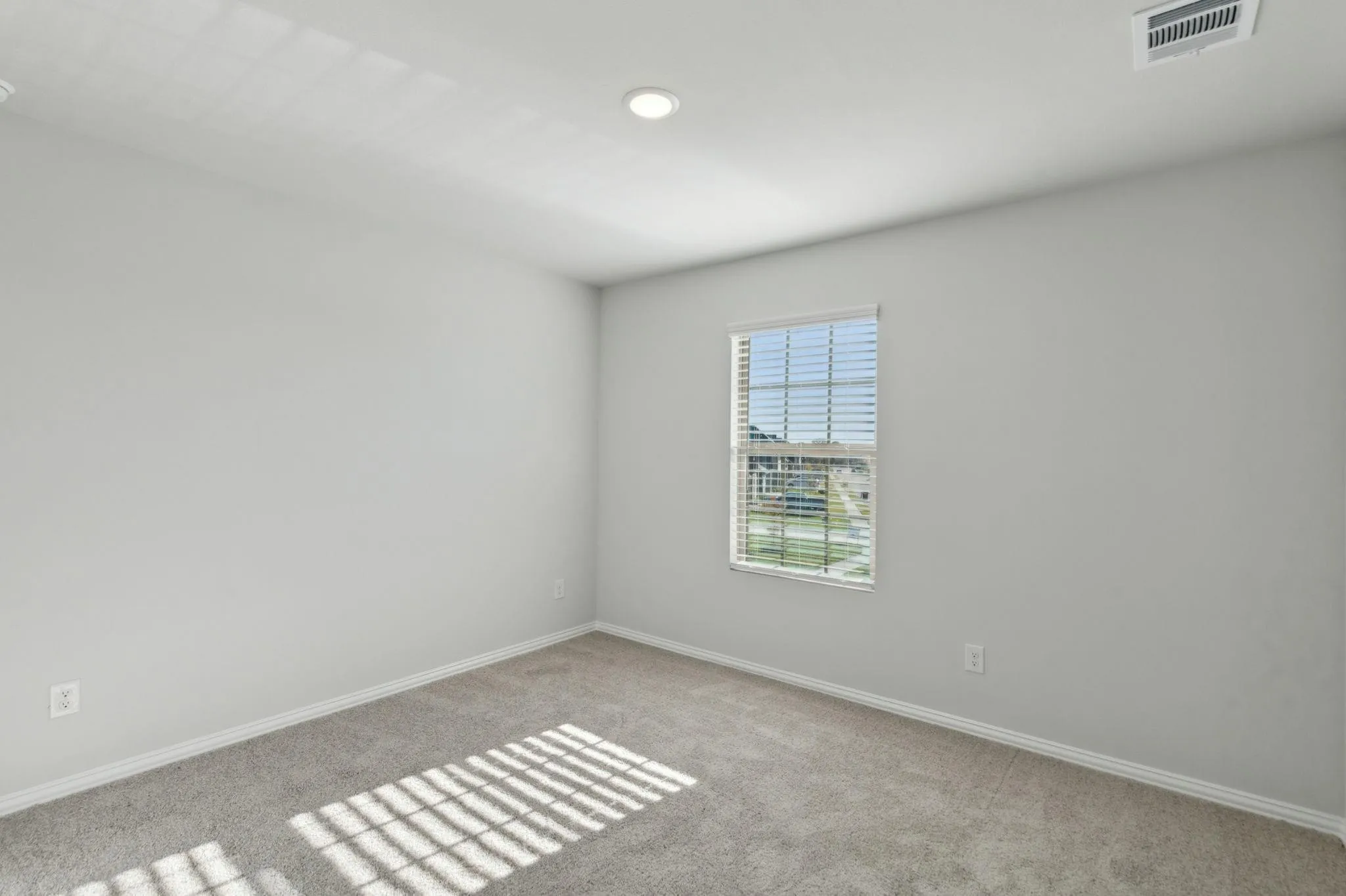 Carpeted spare room with baseboards and recessed lighting
