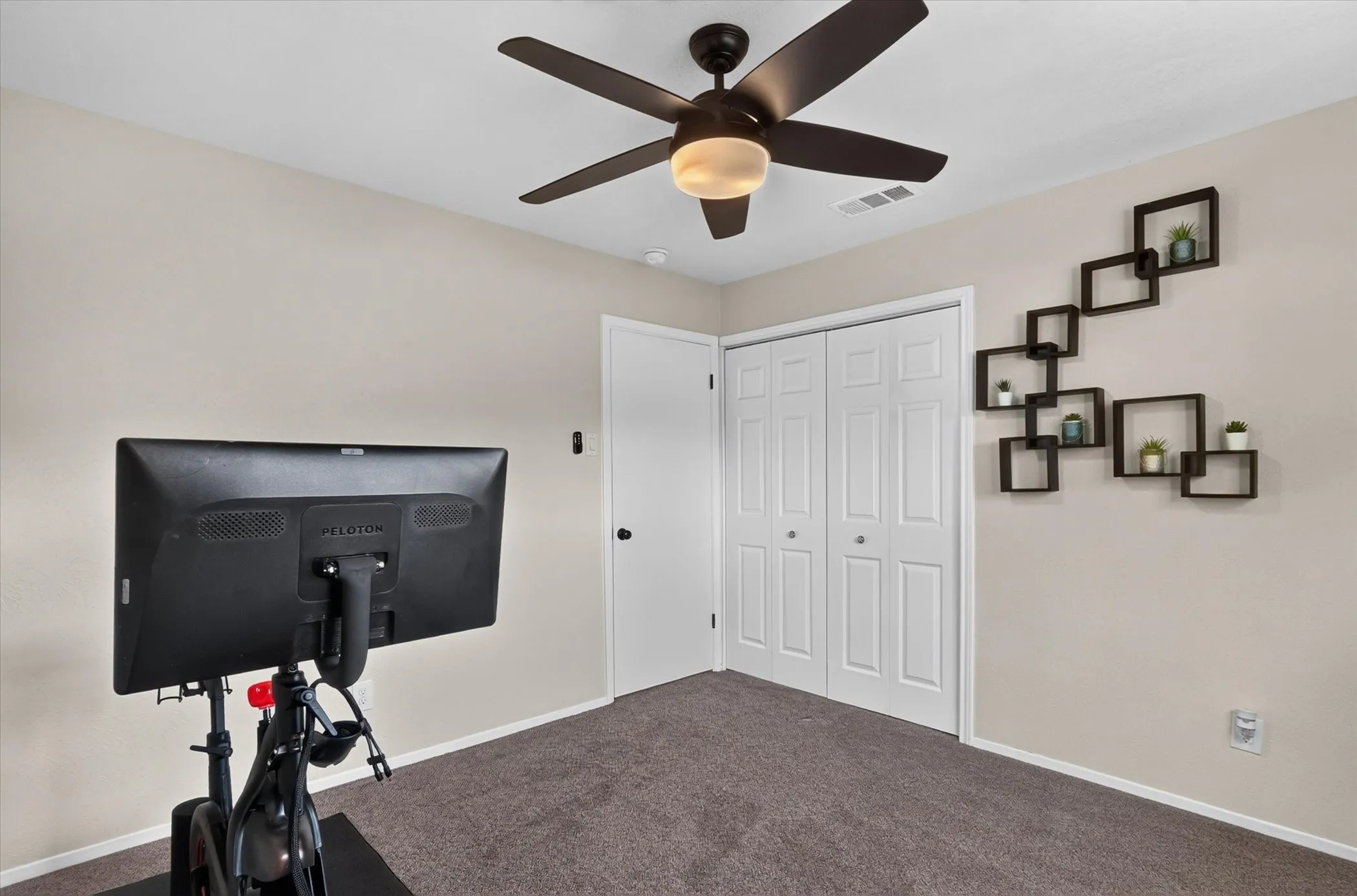 Recessed ceiling fan with integrated lighting, neutral wall paint, bi-fold closet doors, and carpet flooring