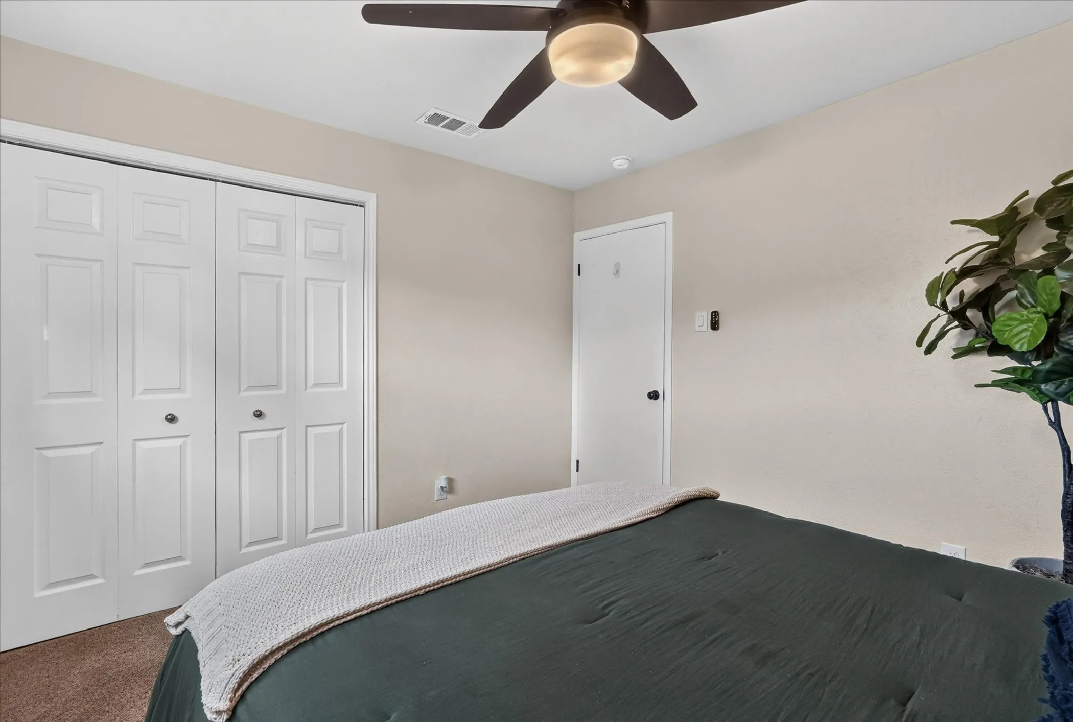 Ceiling fan with integrated lighting, recessed ceiling light, paneled closet doors, interior door with dark hardware, and carpet flooring