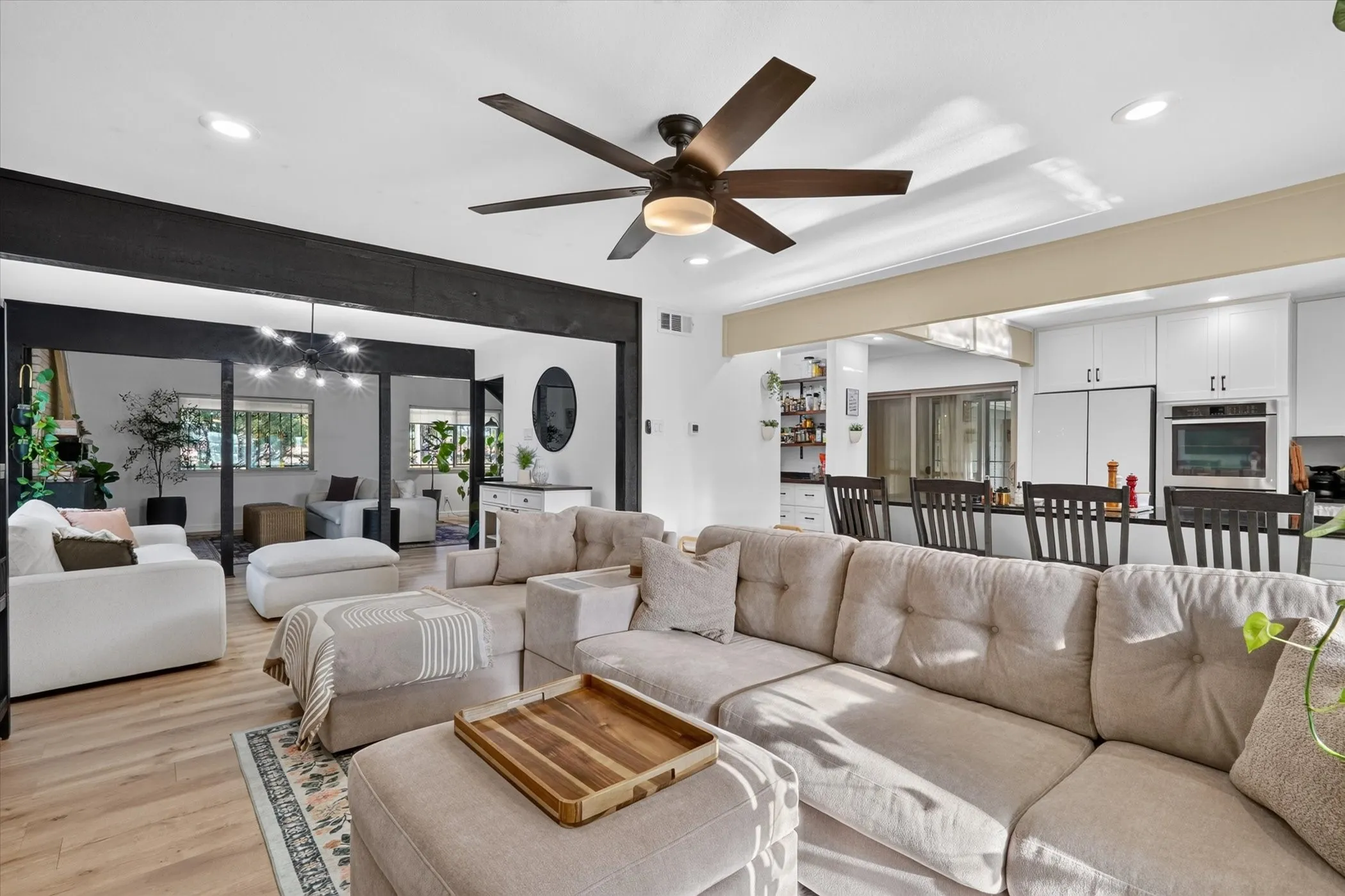 Open-concept living area featuring wood-finish flooring, recessed lighting, and a ceiling fan