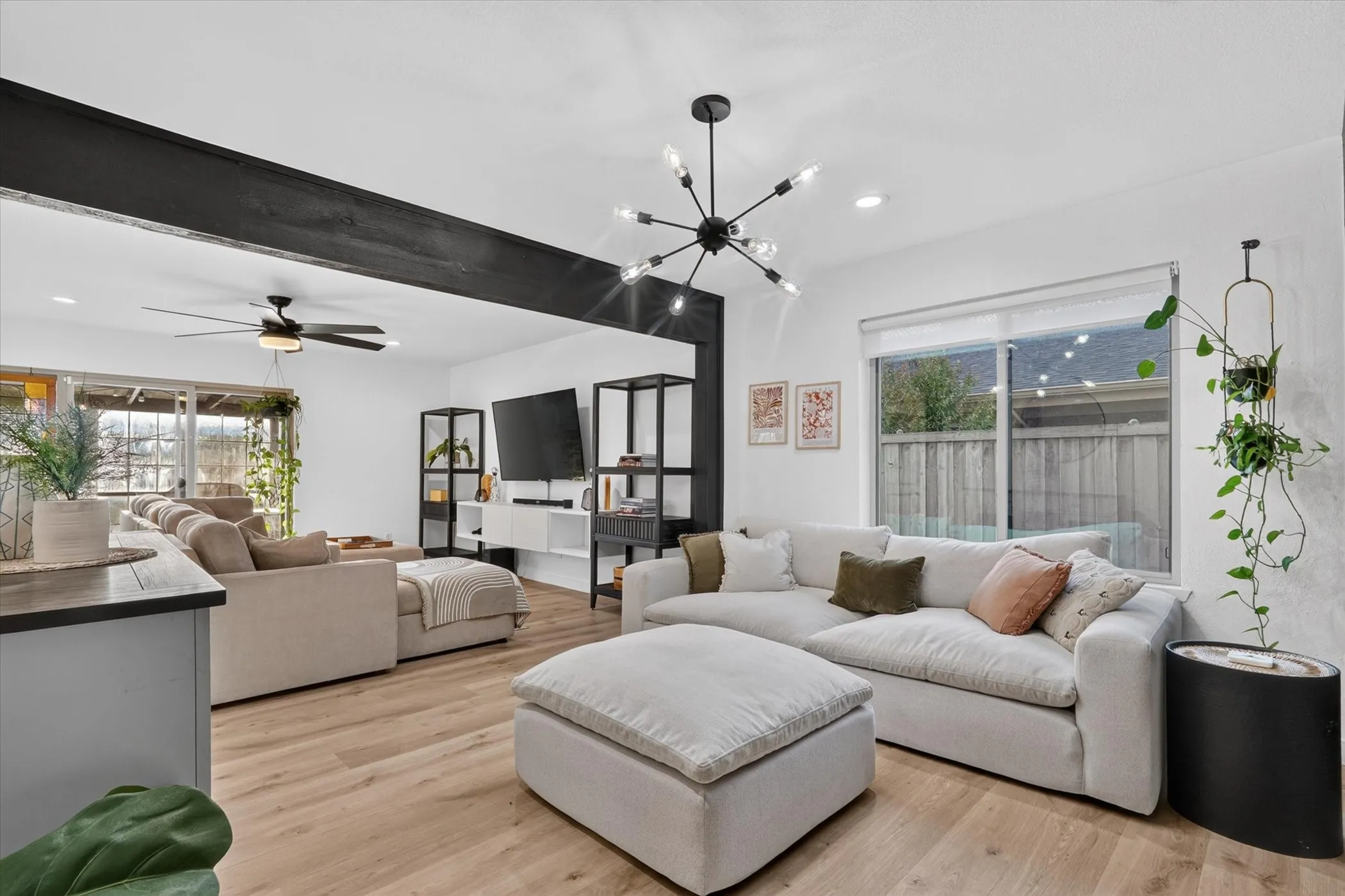 Open-concept living space featuring wood-finish flooring, recessed lighting, and a modern chandelier