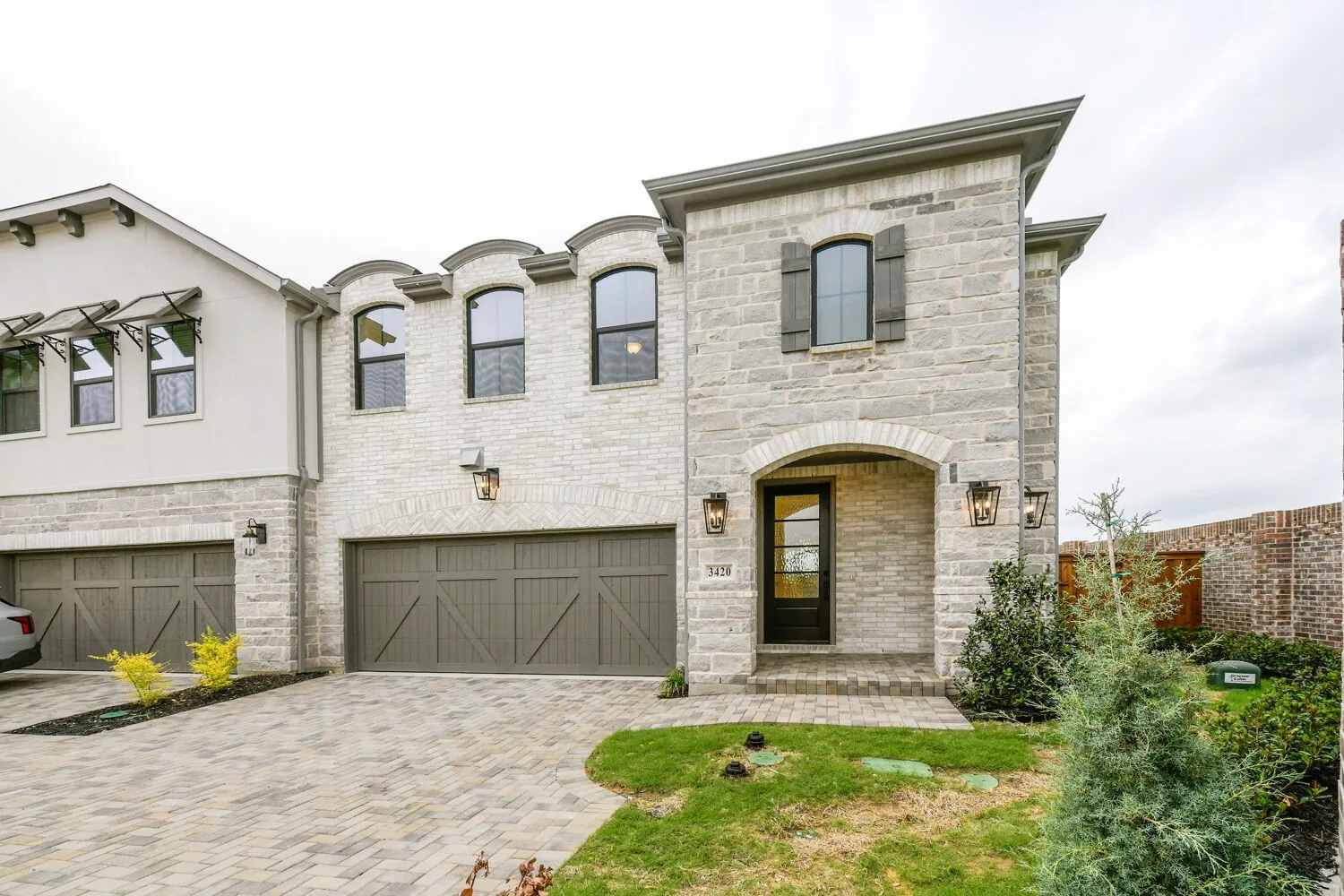Stone facade with arched entry and dark wood shutters