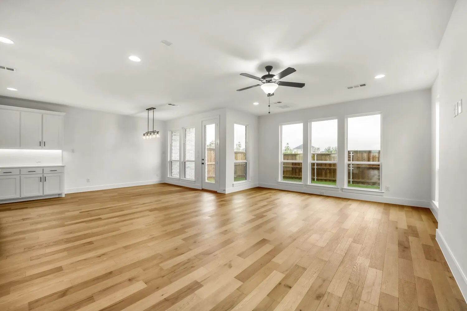 Wood-finish flooring, recessed lighting, and a ceiling fan