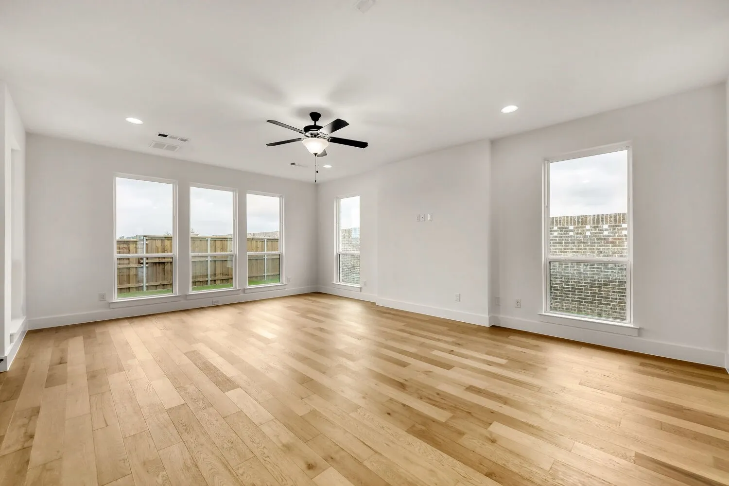 Family room with wood flooring, recessed lighting, and a ceiling fan